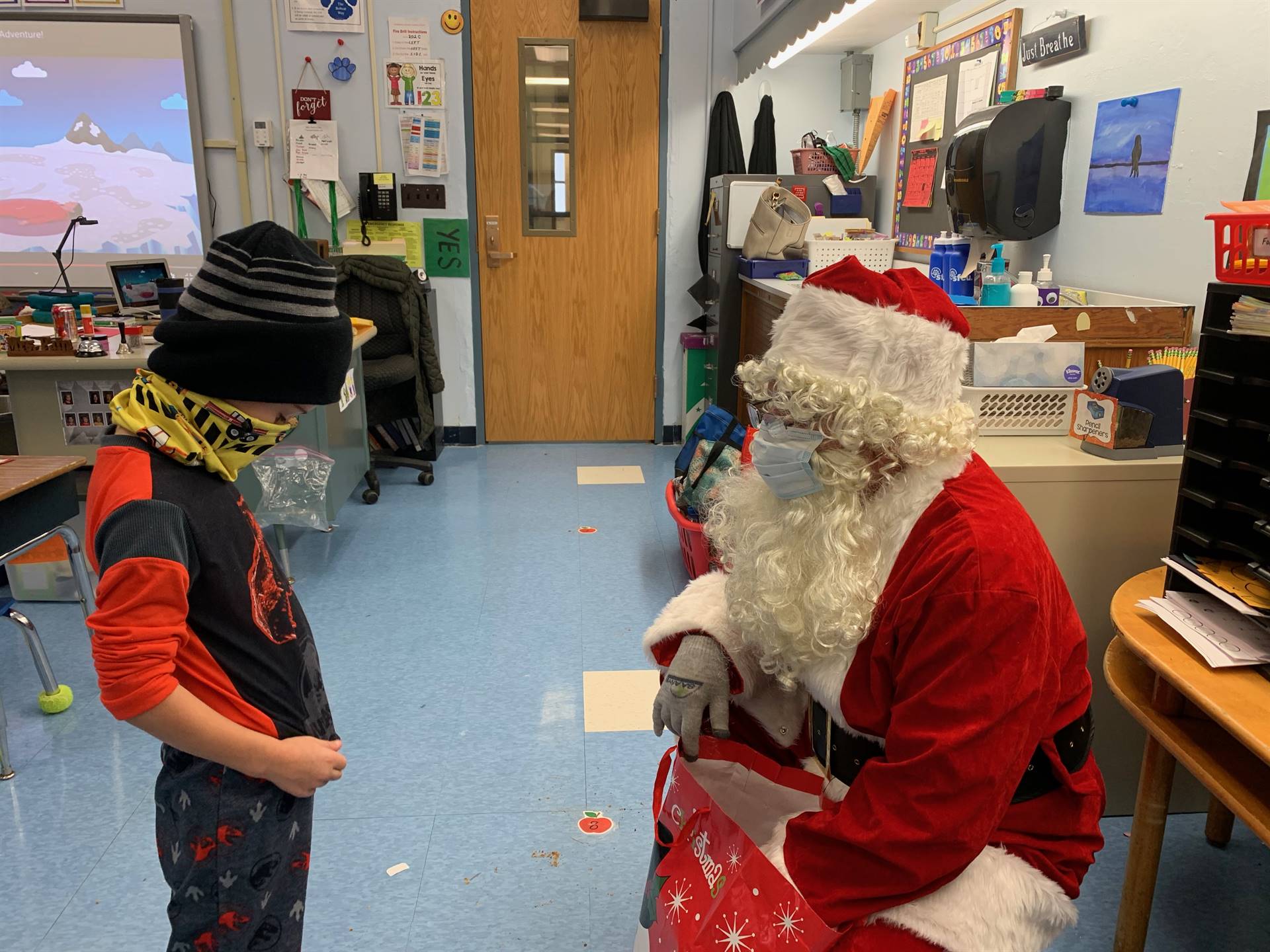 Santa looks at a student's shirt.