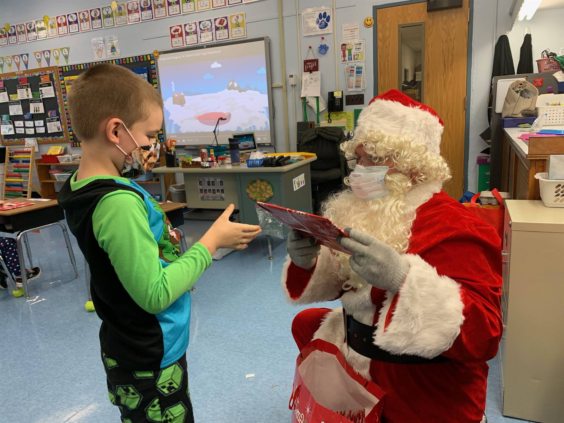 Santa hands a gift out to a child.