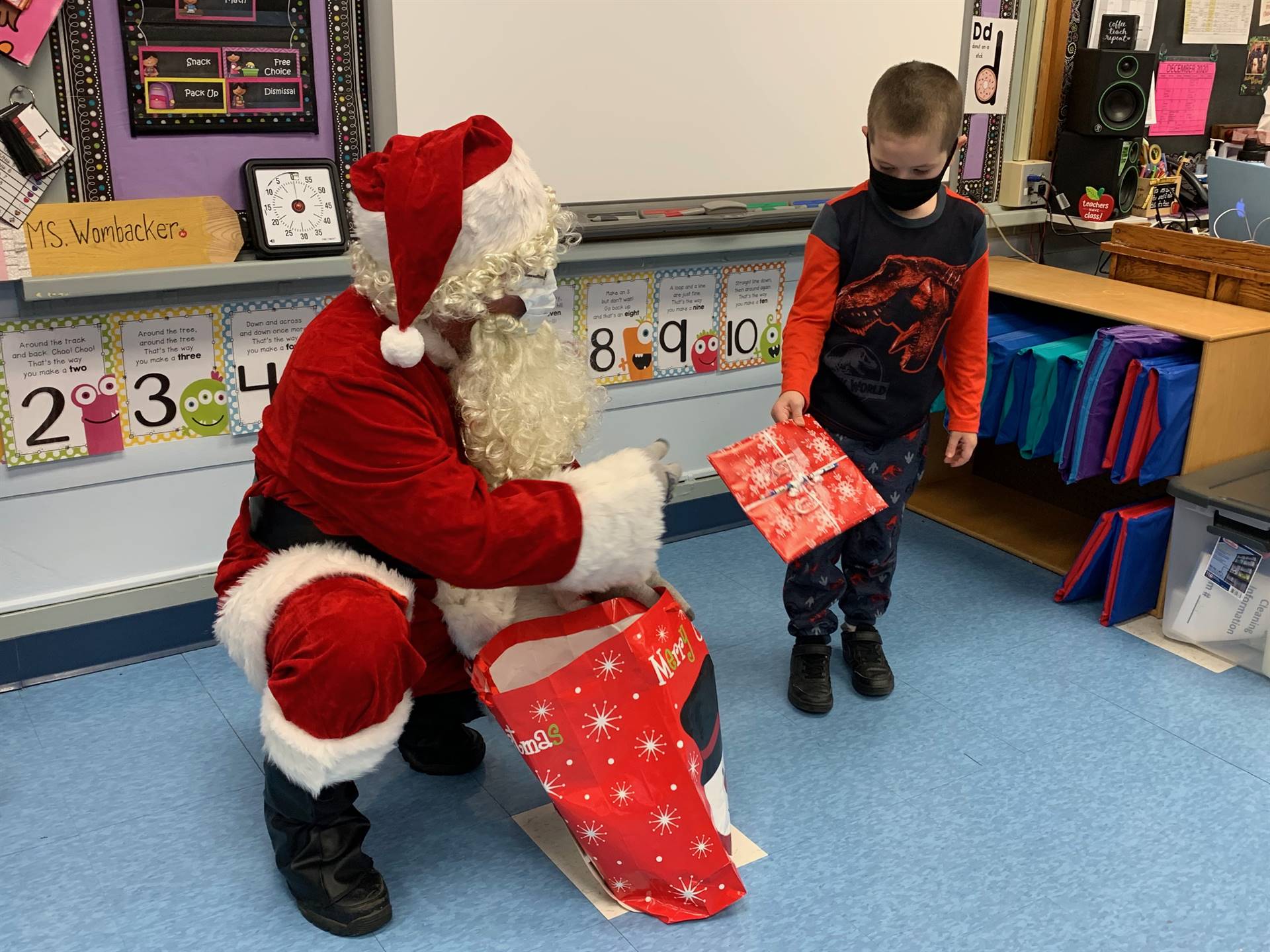 Santa hands a gift out to a child.