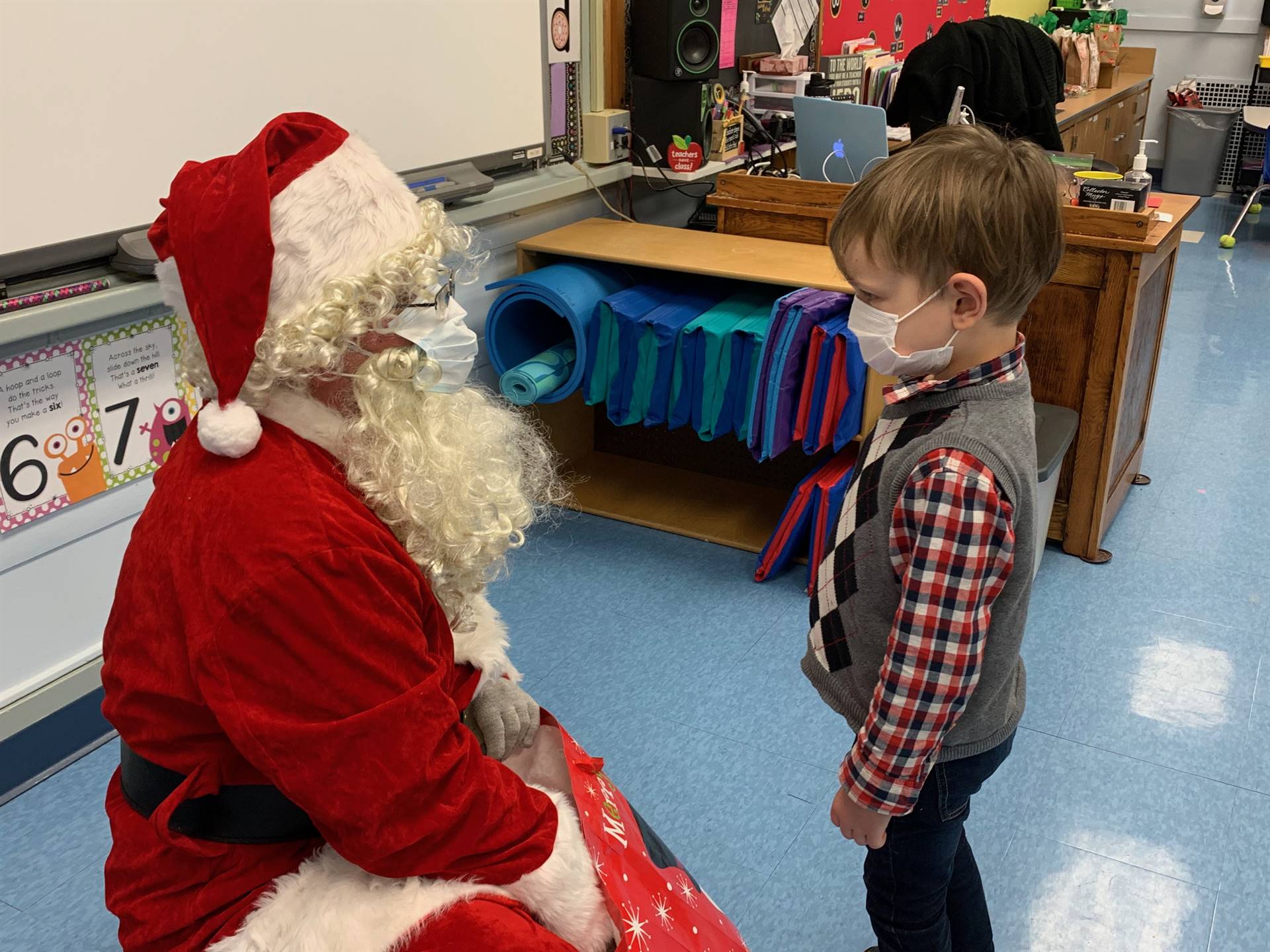 Santa hands a gift out to a child.