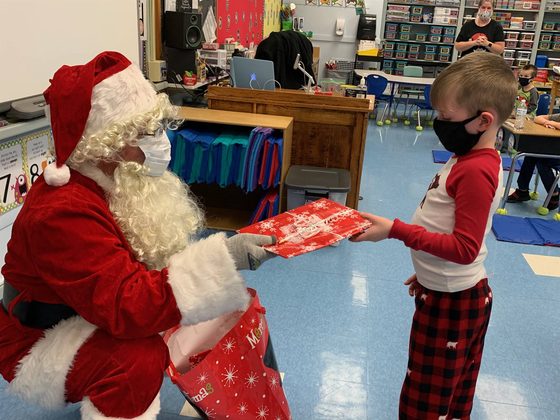 Santa hands a gift out to a child.