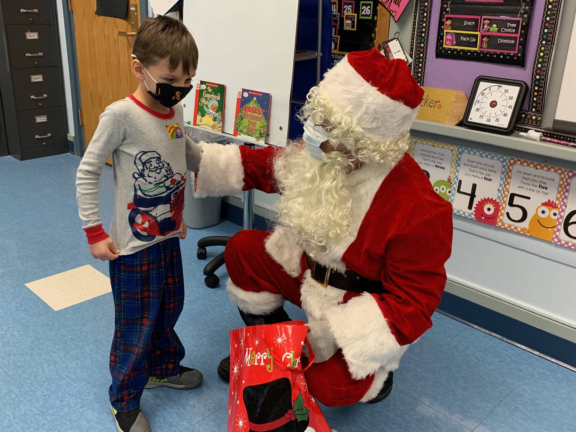 Santa hands a gift out to a child.