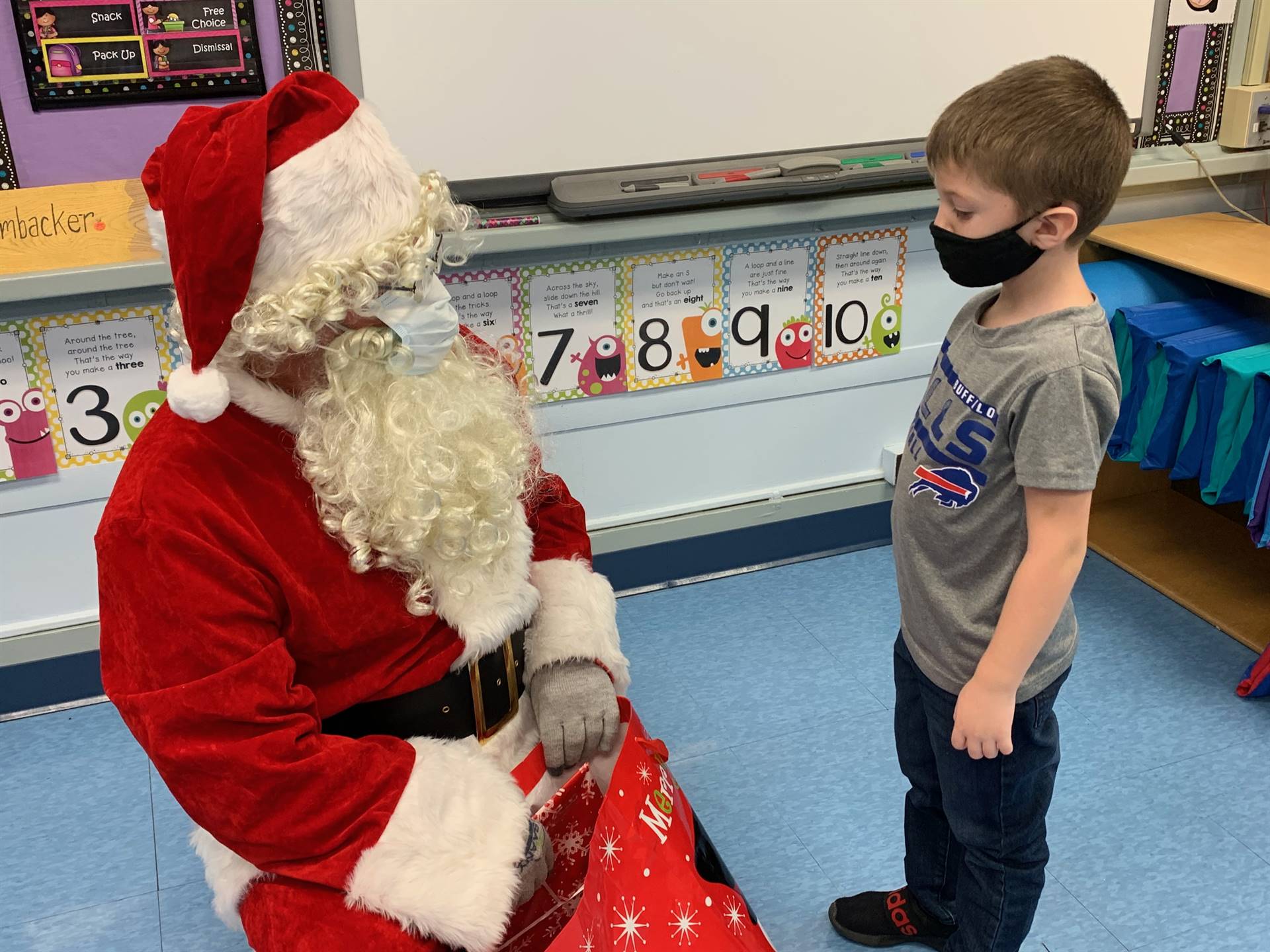 Santa hands a gift out to a child.