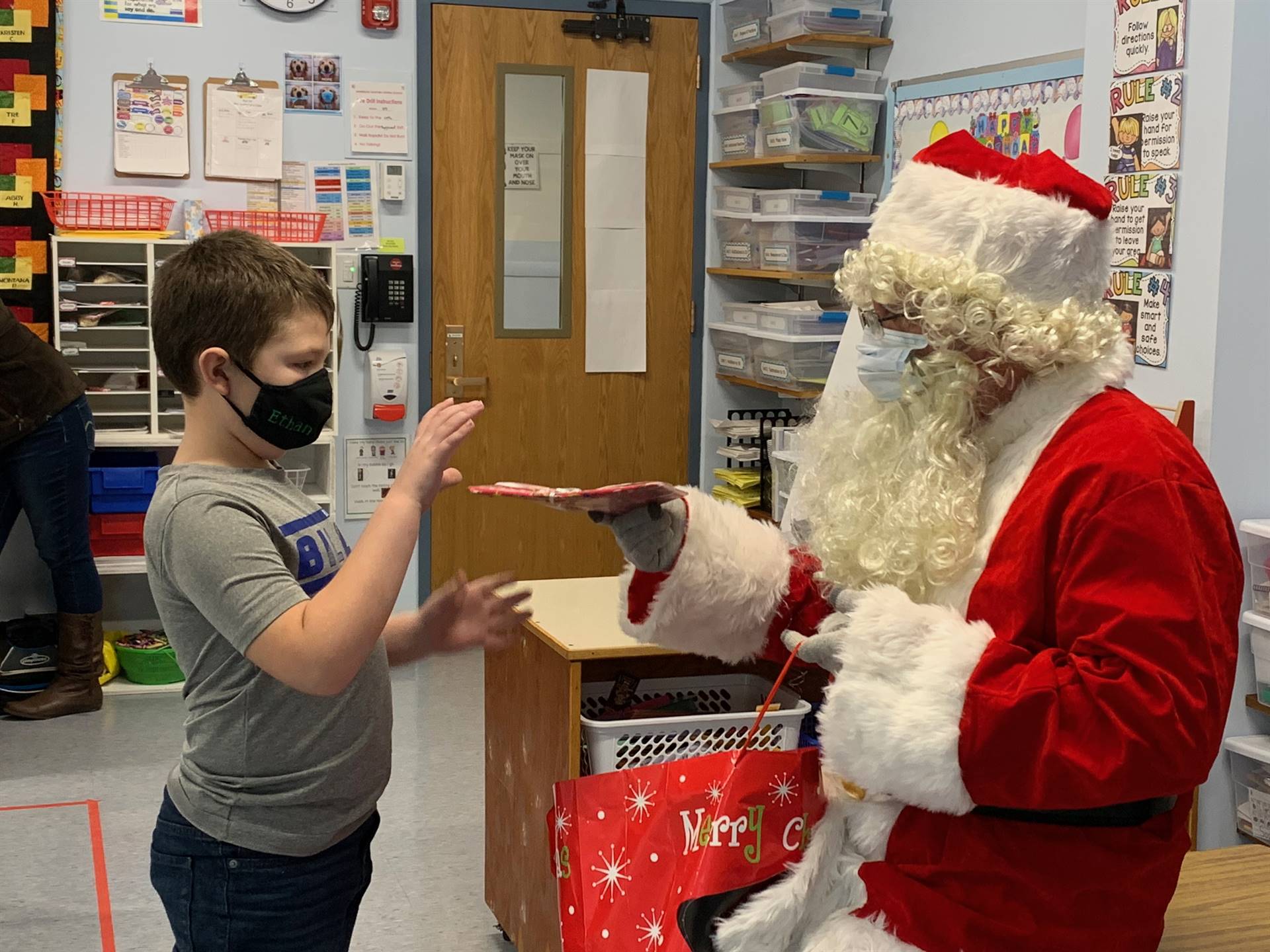 Santa hands a gift out to a child.