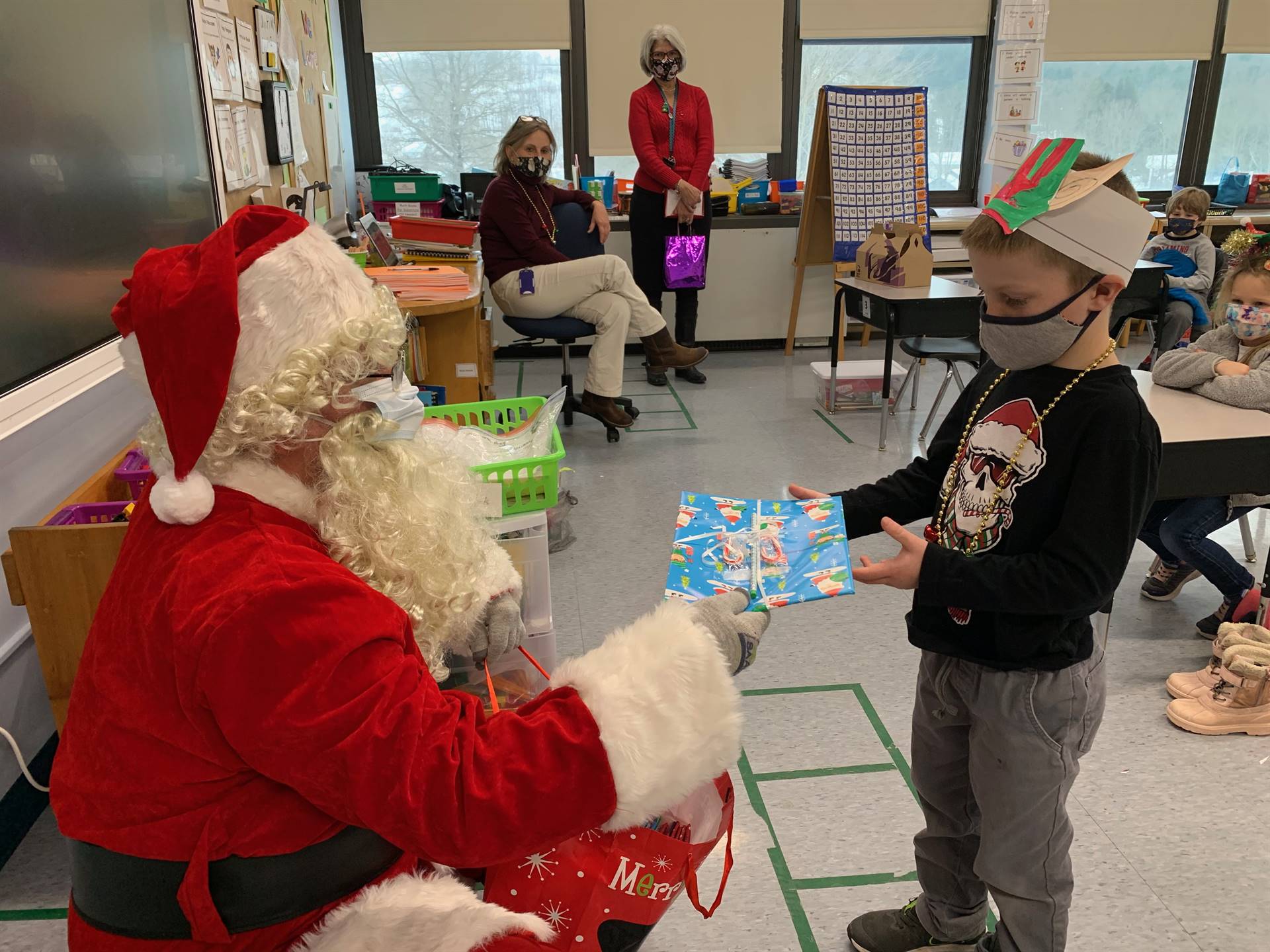 Santa hands a gift out to a child.