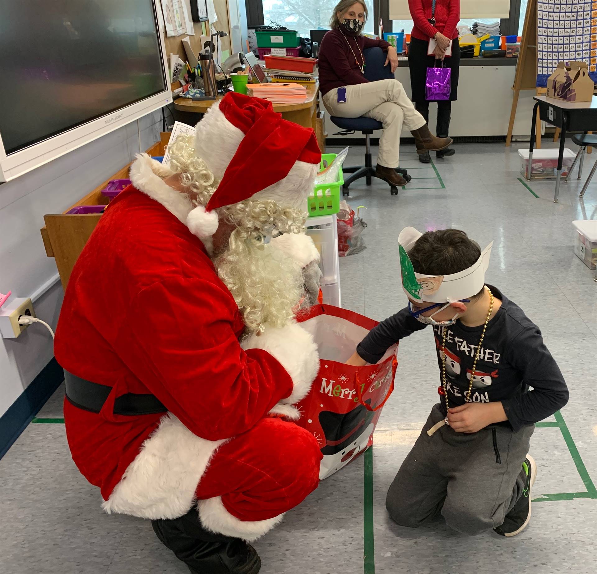 A student picks a gift from Santa's bag.