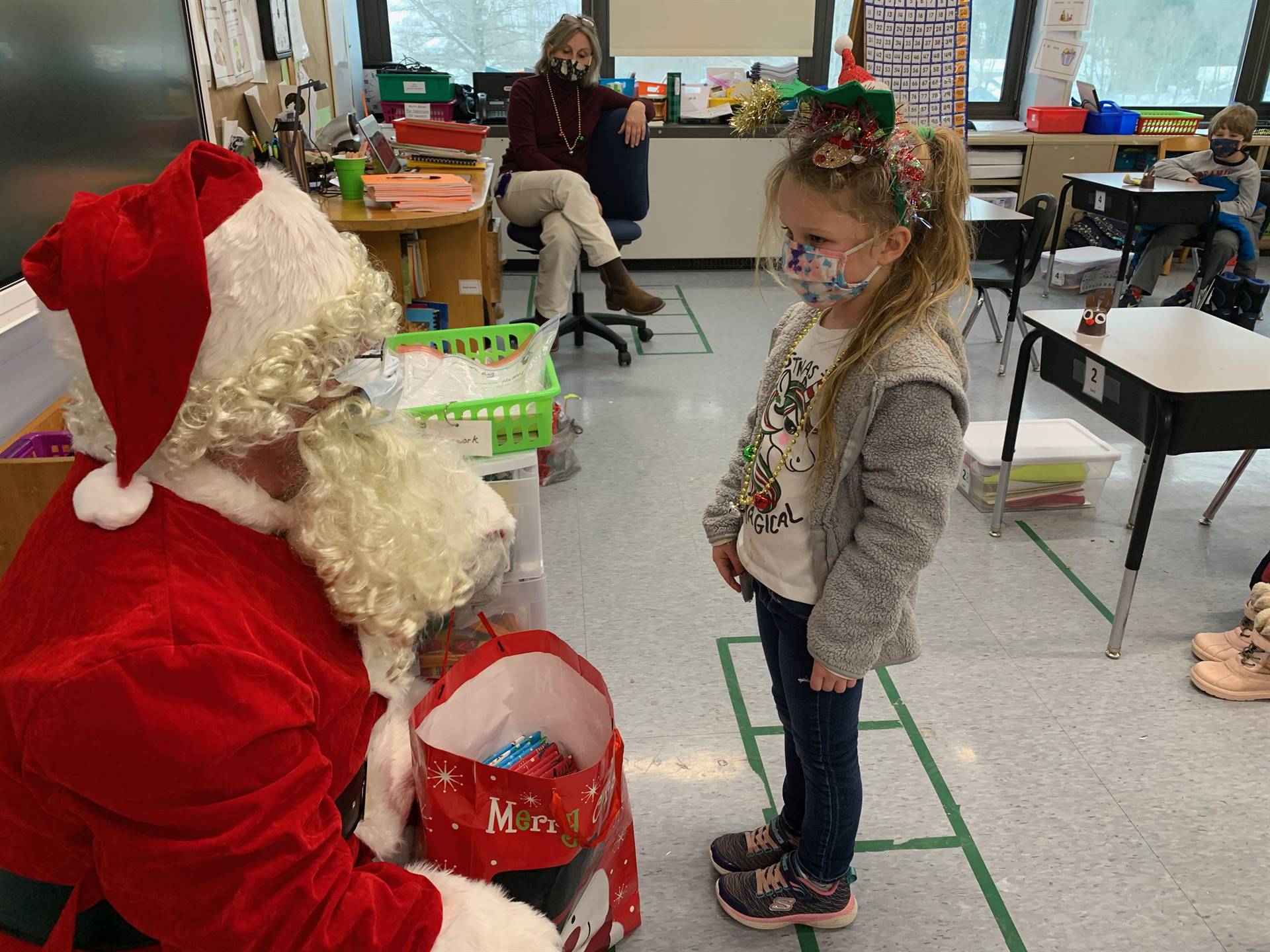 Santa hands a gift out to a child.