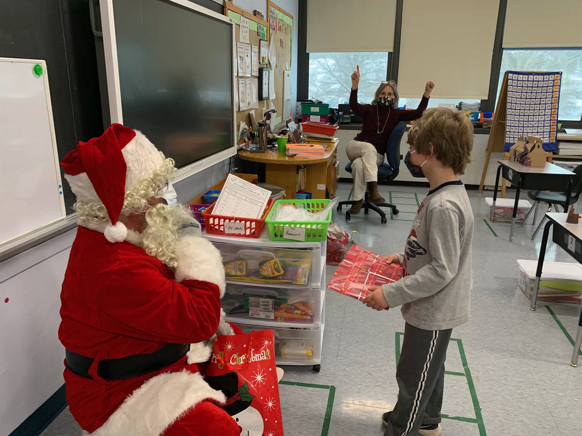 Santa hands a gift out to a child.