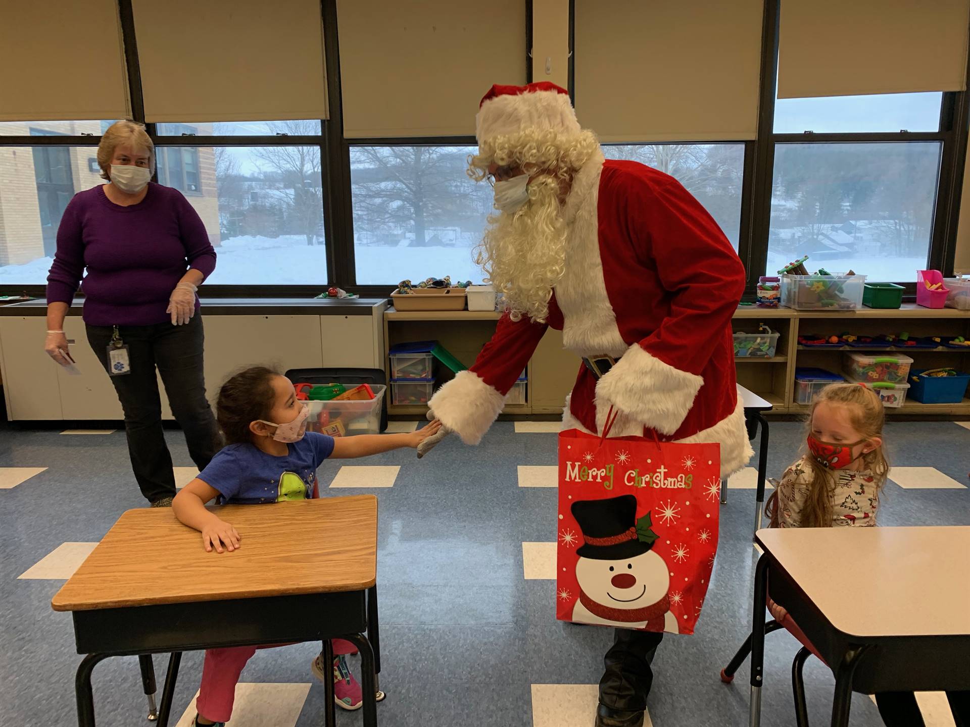 Santa gives a high 5 to a student.