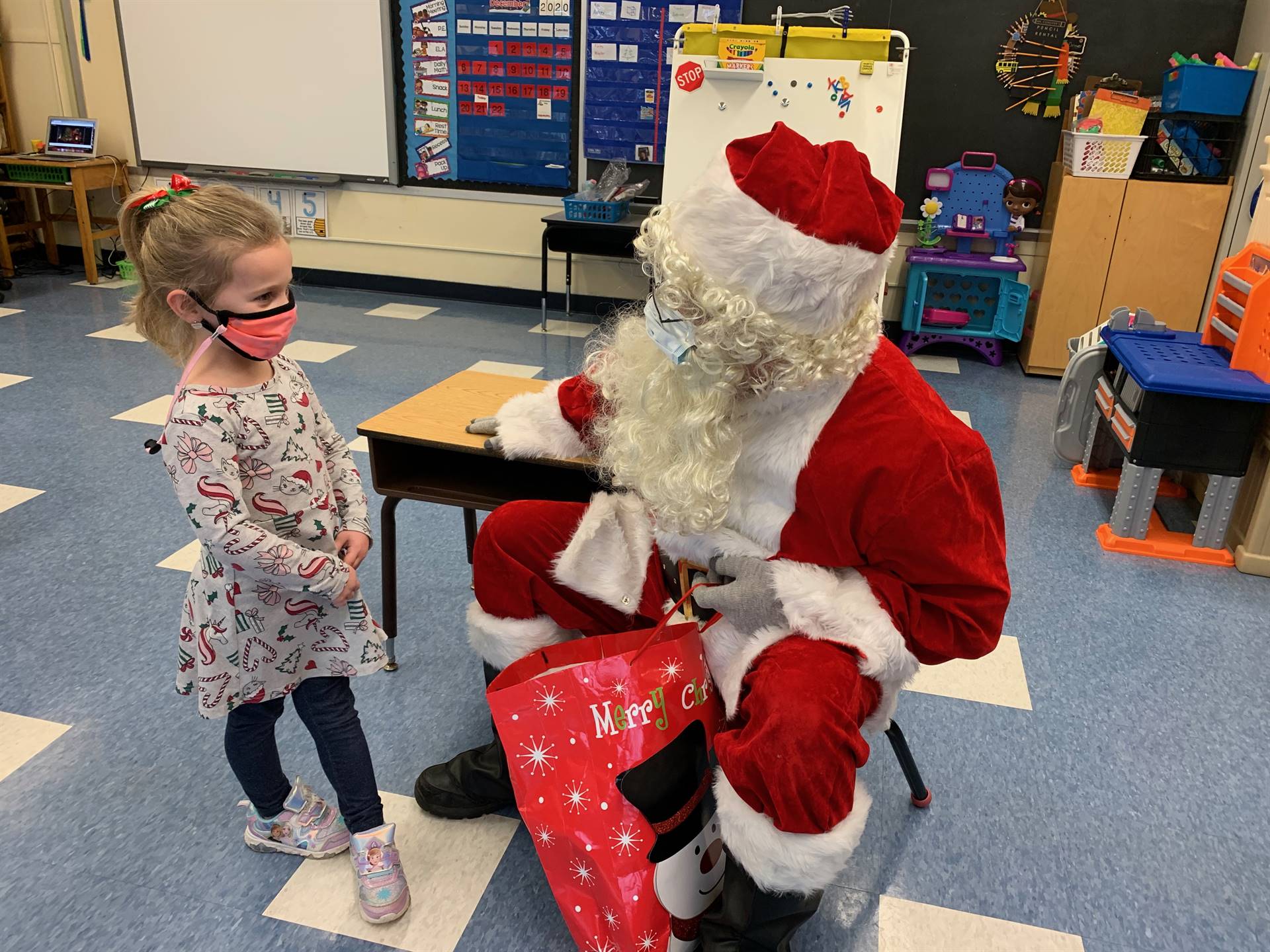 Santa asks a student if she is good.