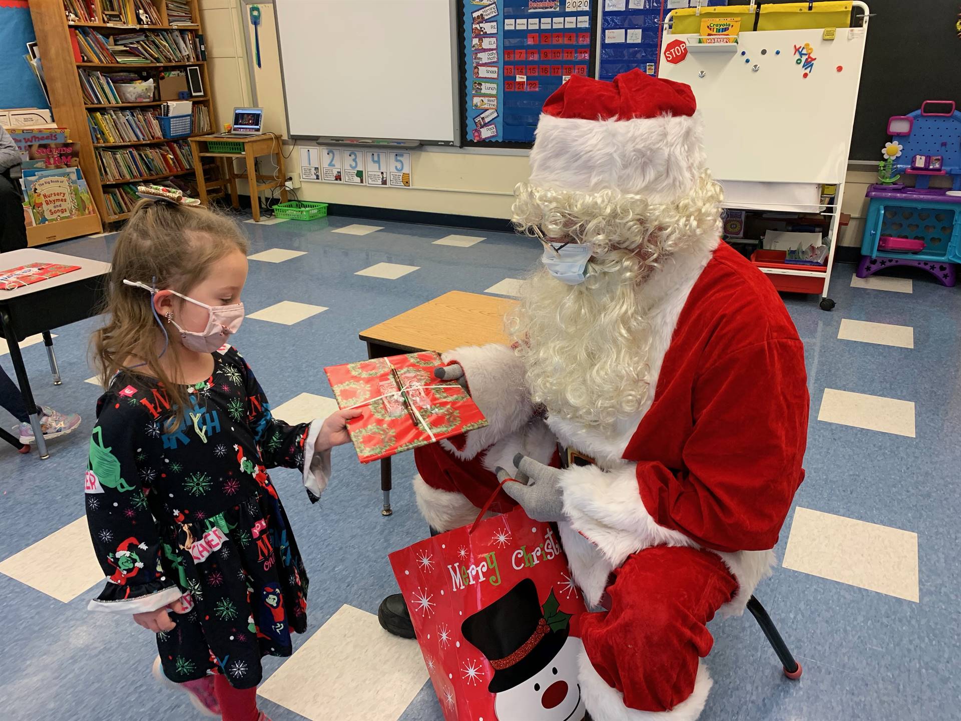 Santa hands a gift out to a child.