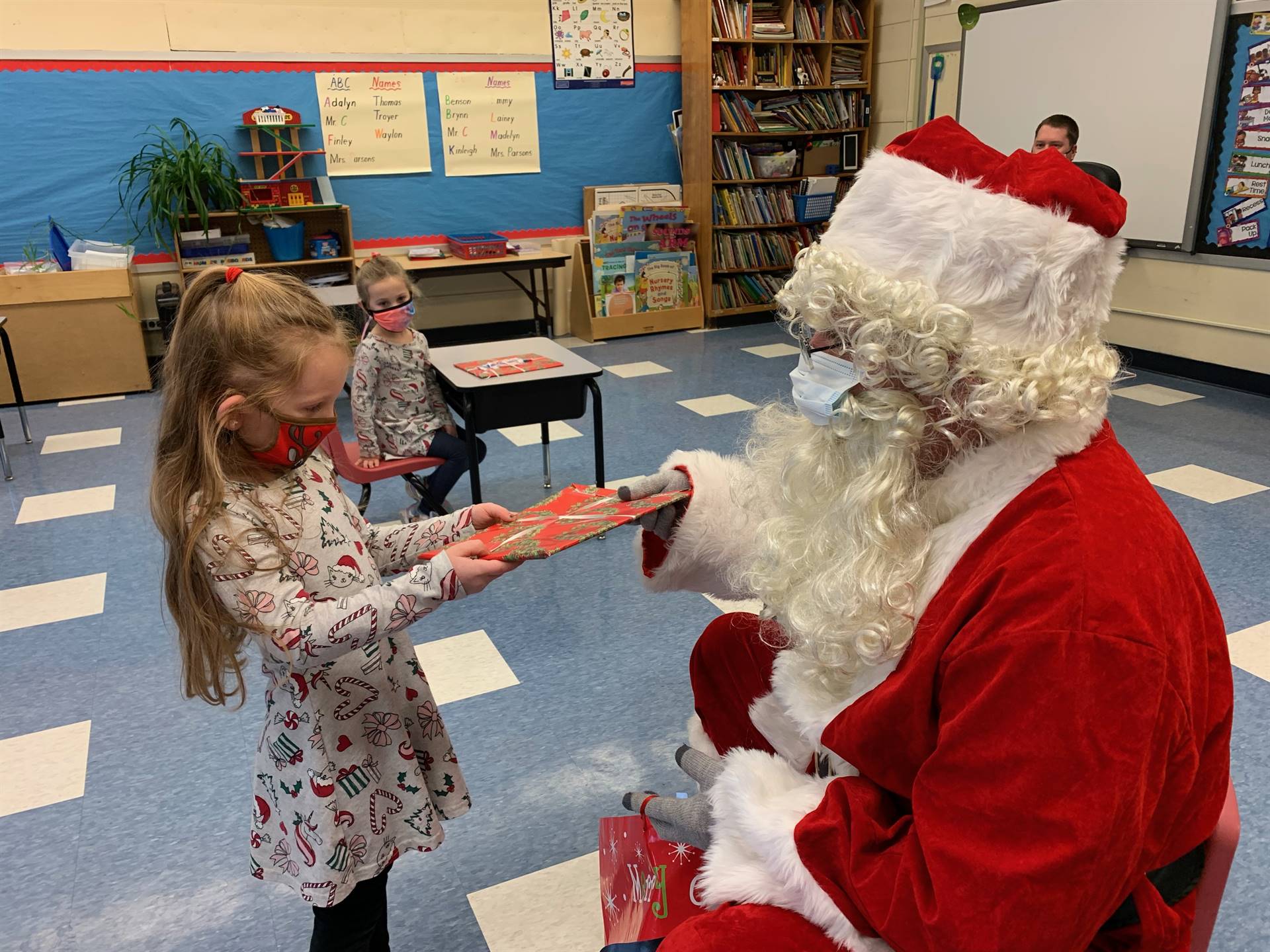 Santa hands a gift out to a child.