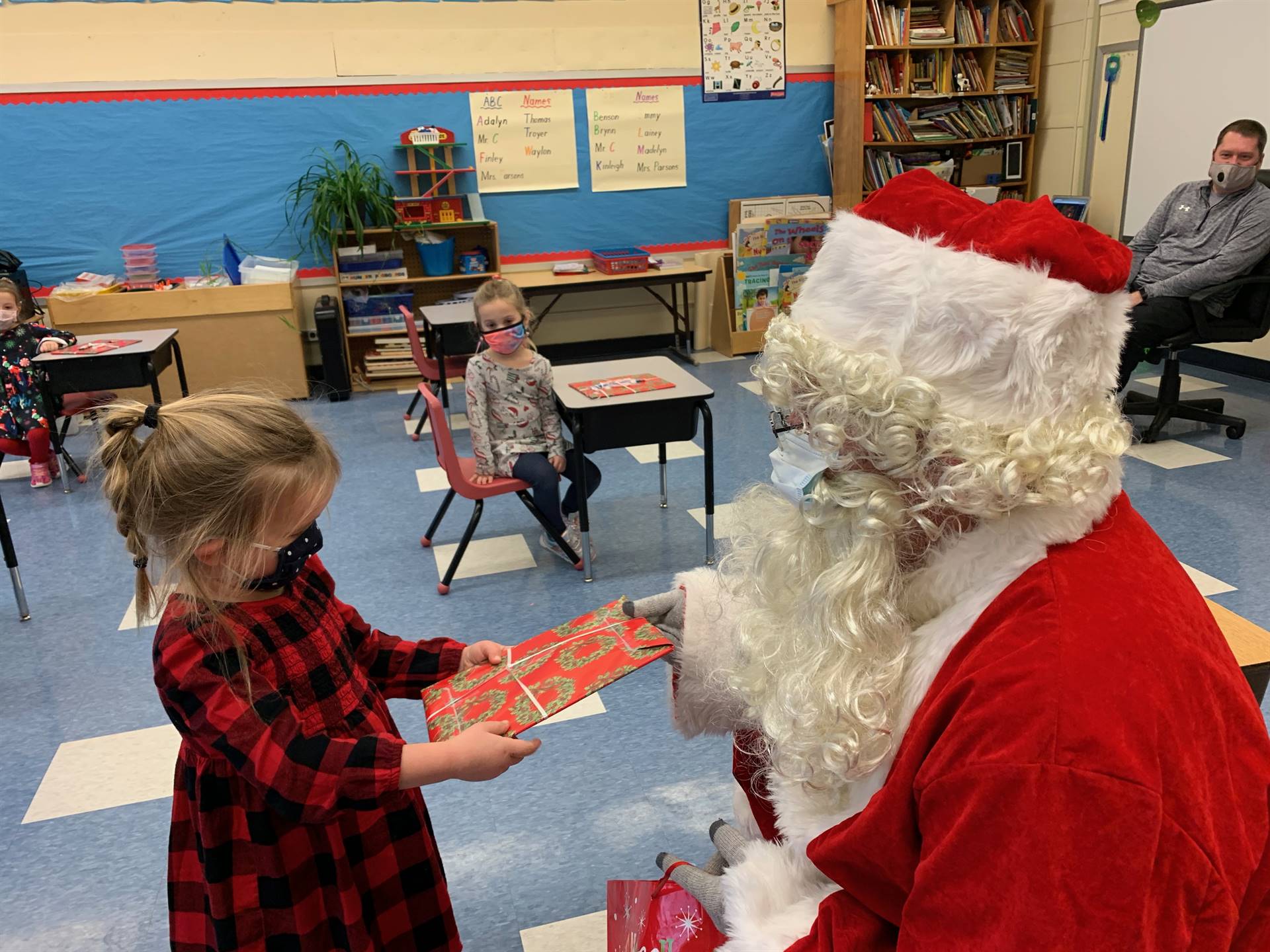 Santa hands a gift out to a child.