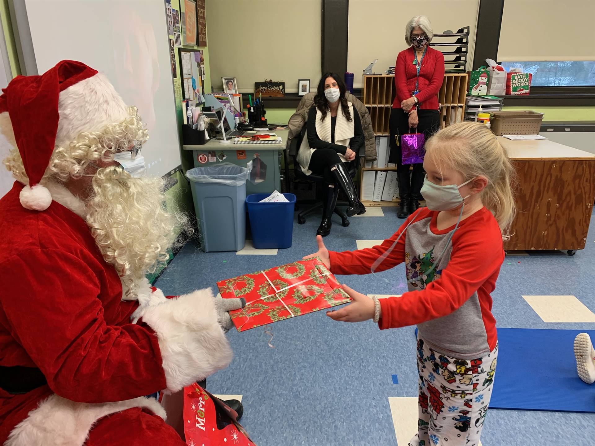 Santa hands a gift out to a child.