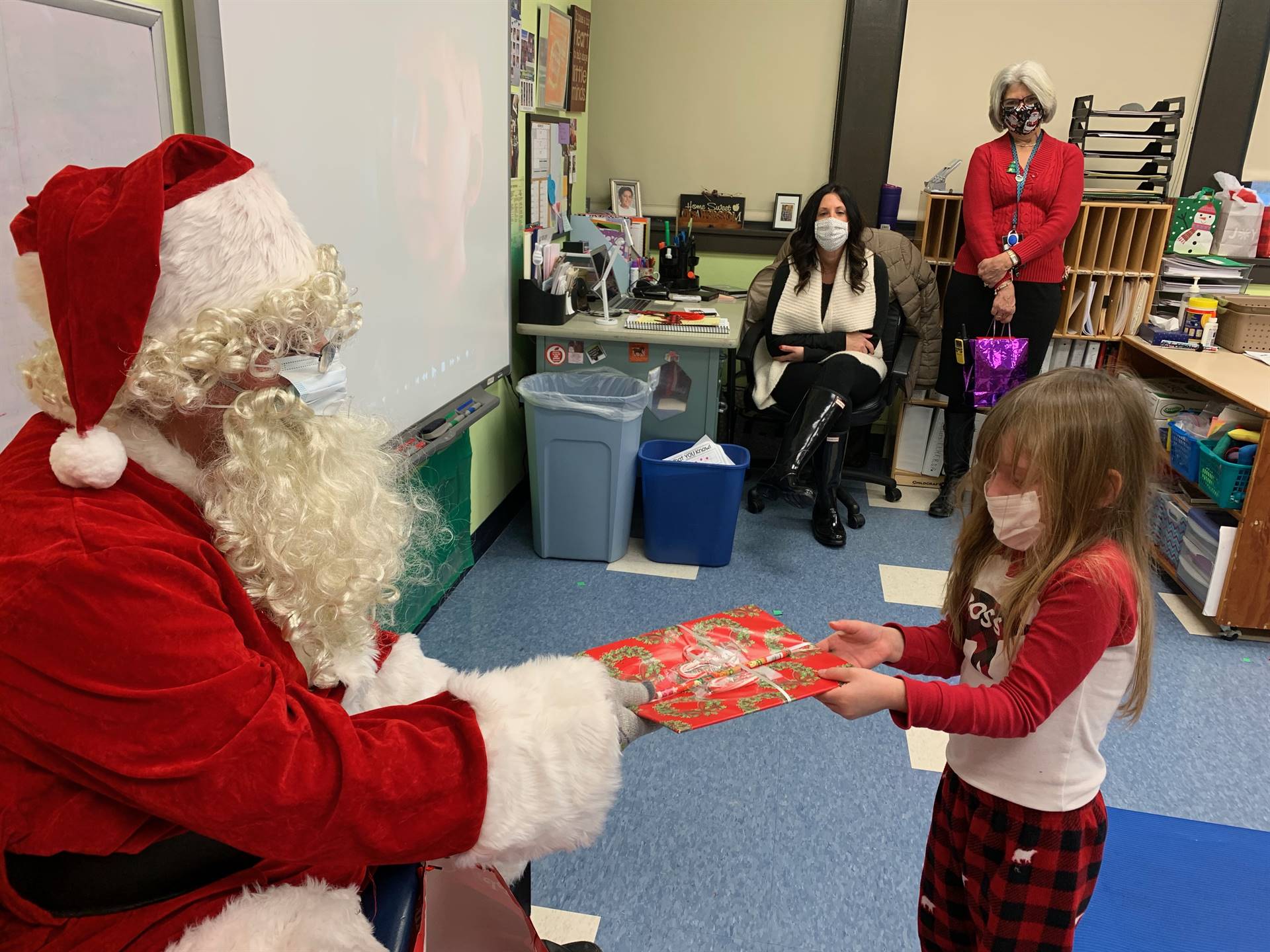 Santa hands a gift out to a child.