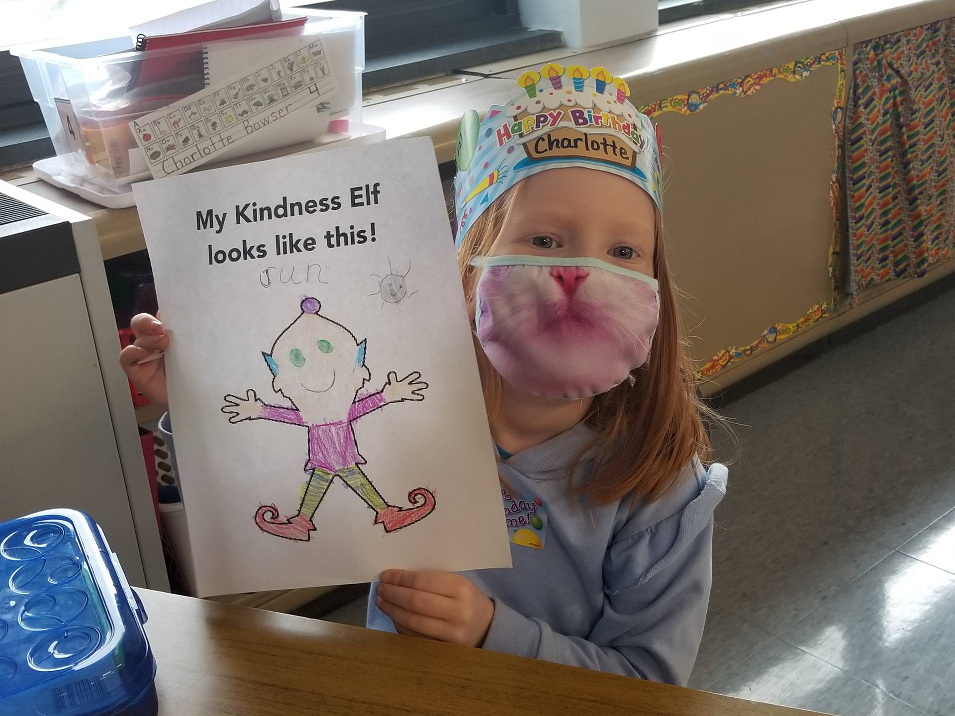 students shows a colored page of the kindness elf