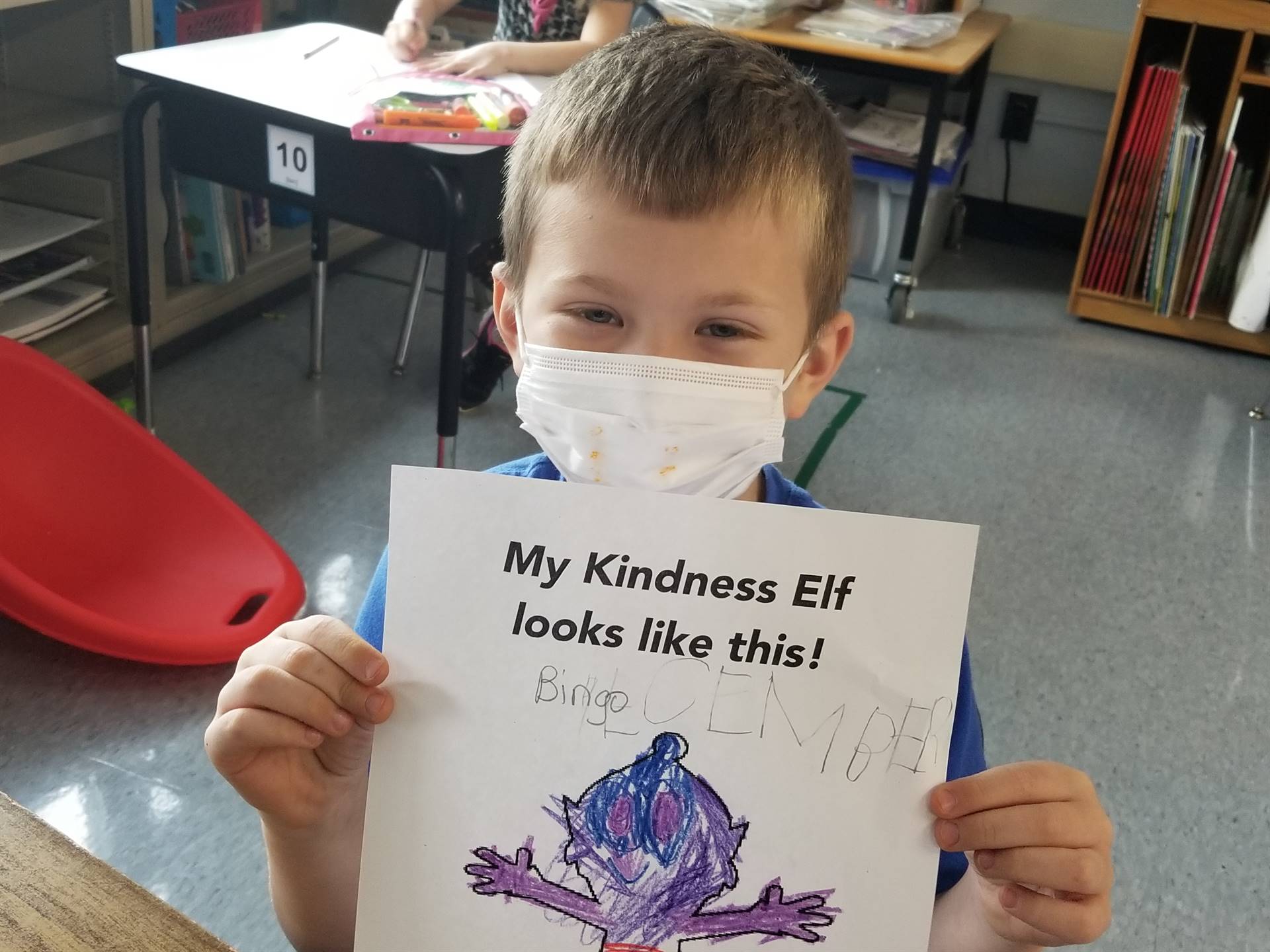 students shows a colored page of the kindness elf