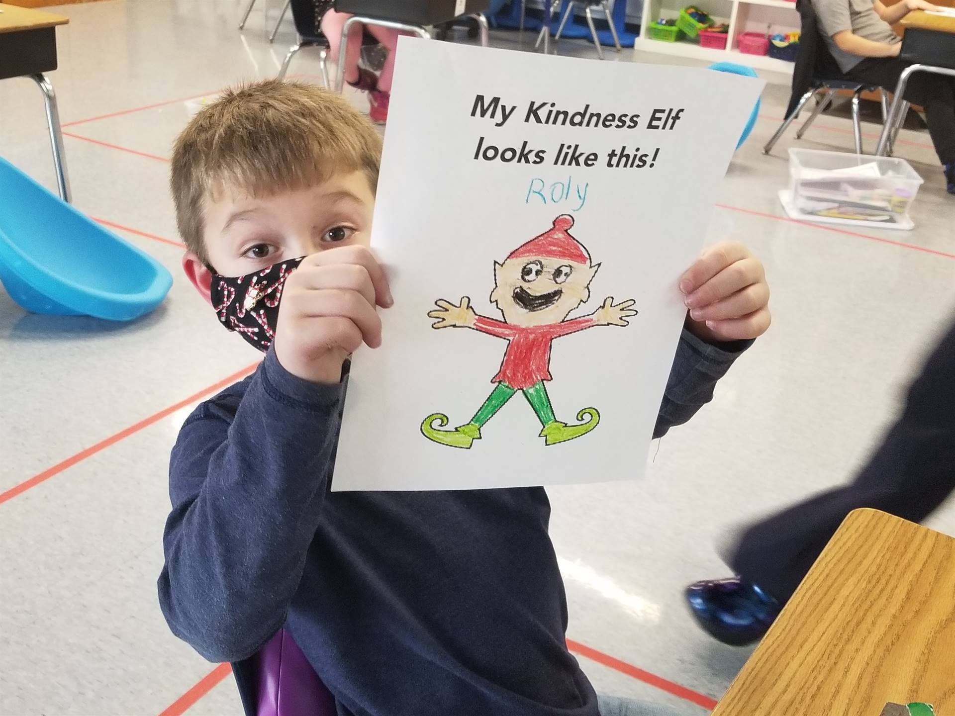 students shows a picture of the kindness elf