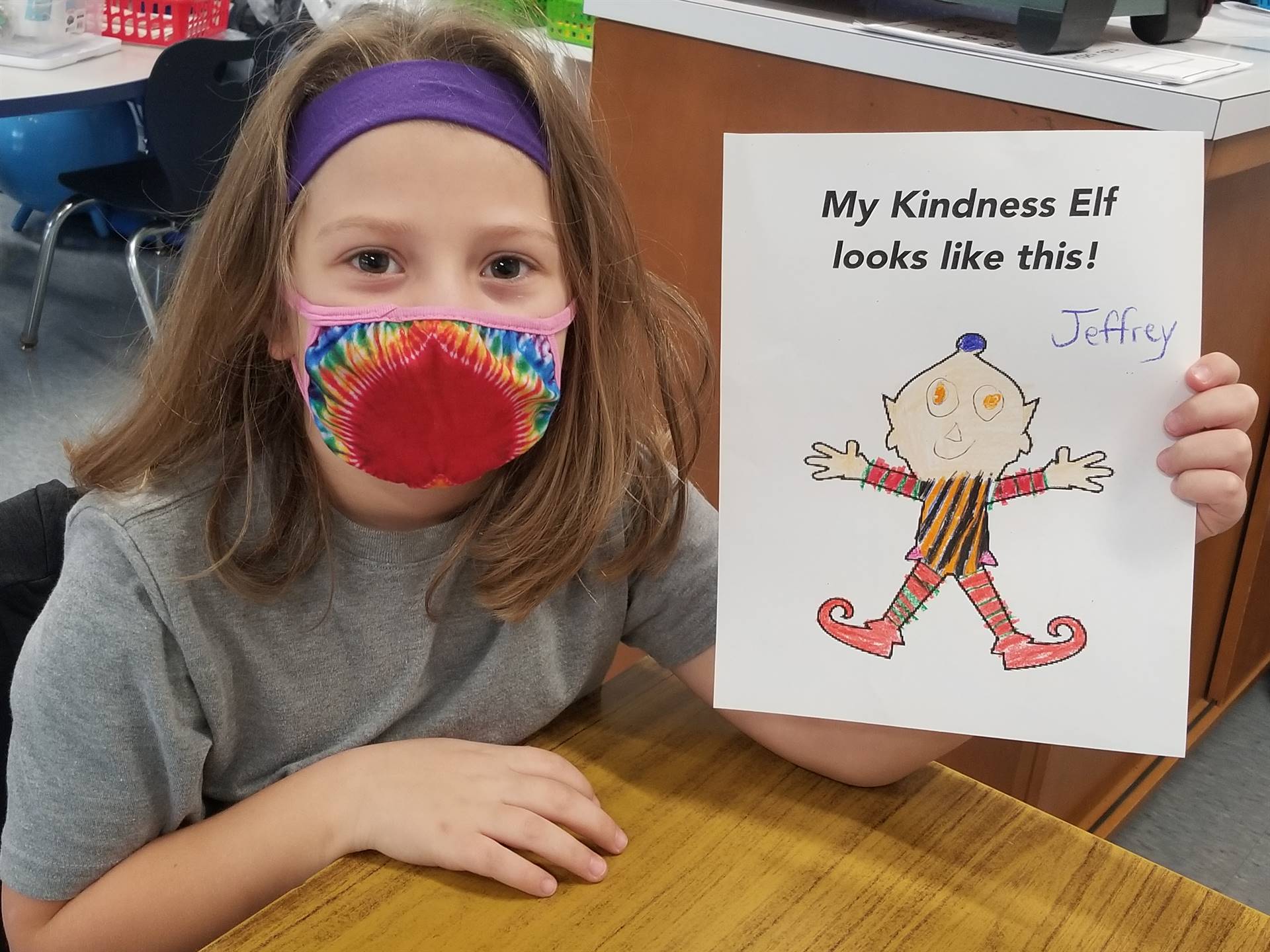 students shows a picture of the kindness elf