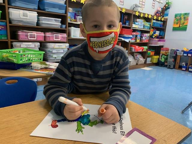 A student colors his kindness elf