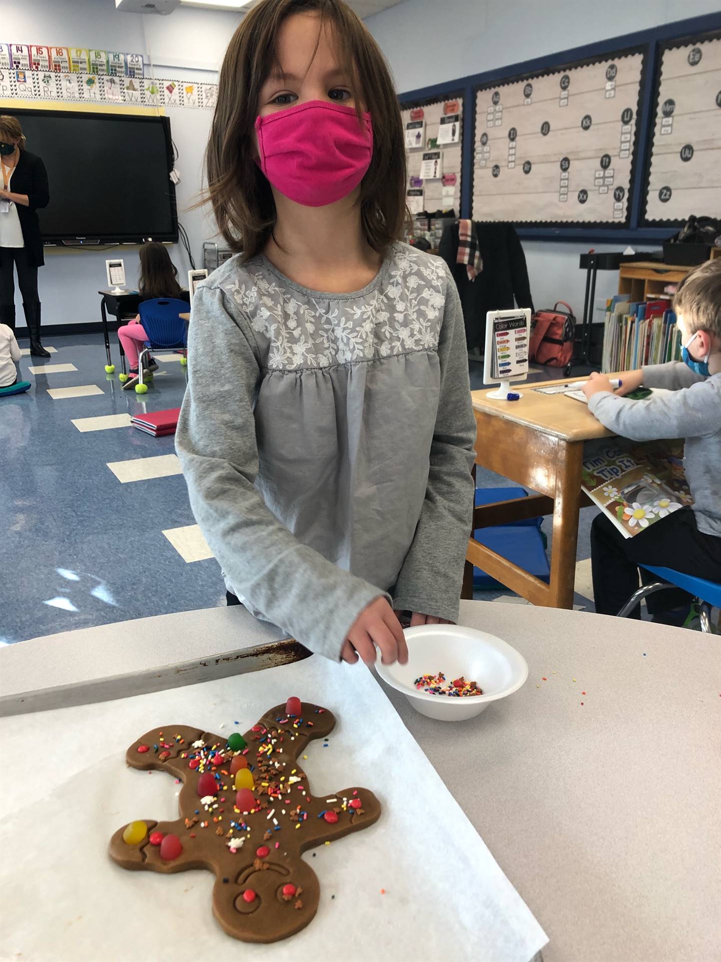 Child shows decorated gingerbread cookie