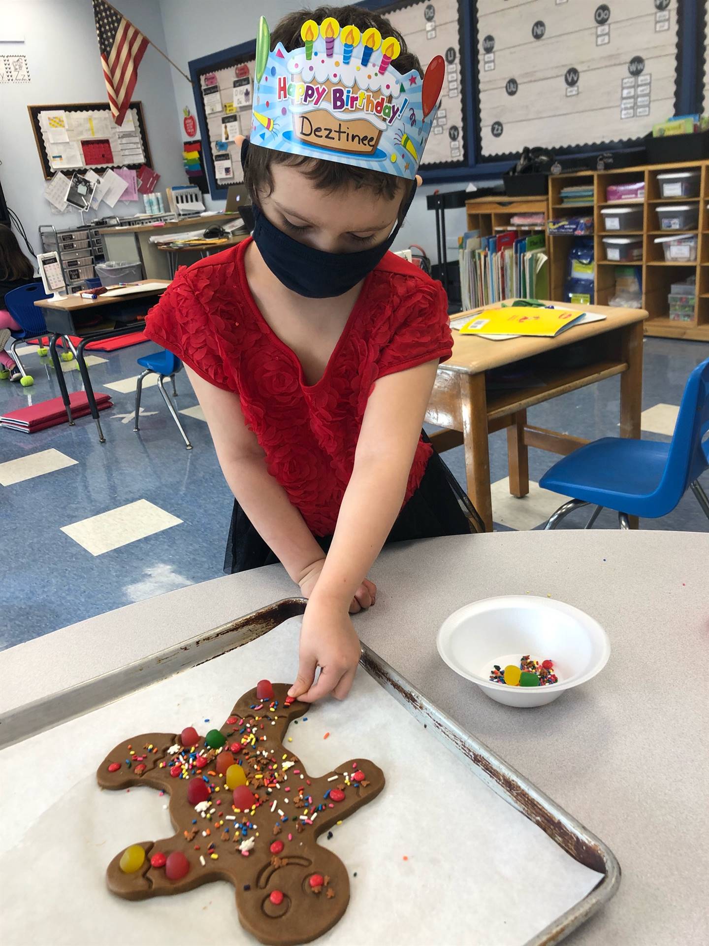 Child Sprinkling candy on a giant gingerbread cookie!