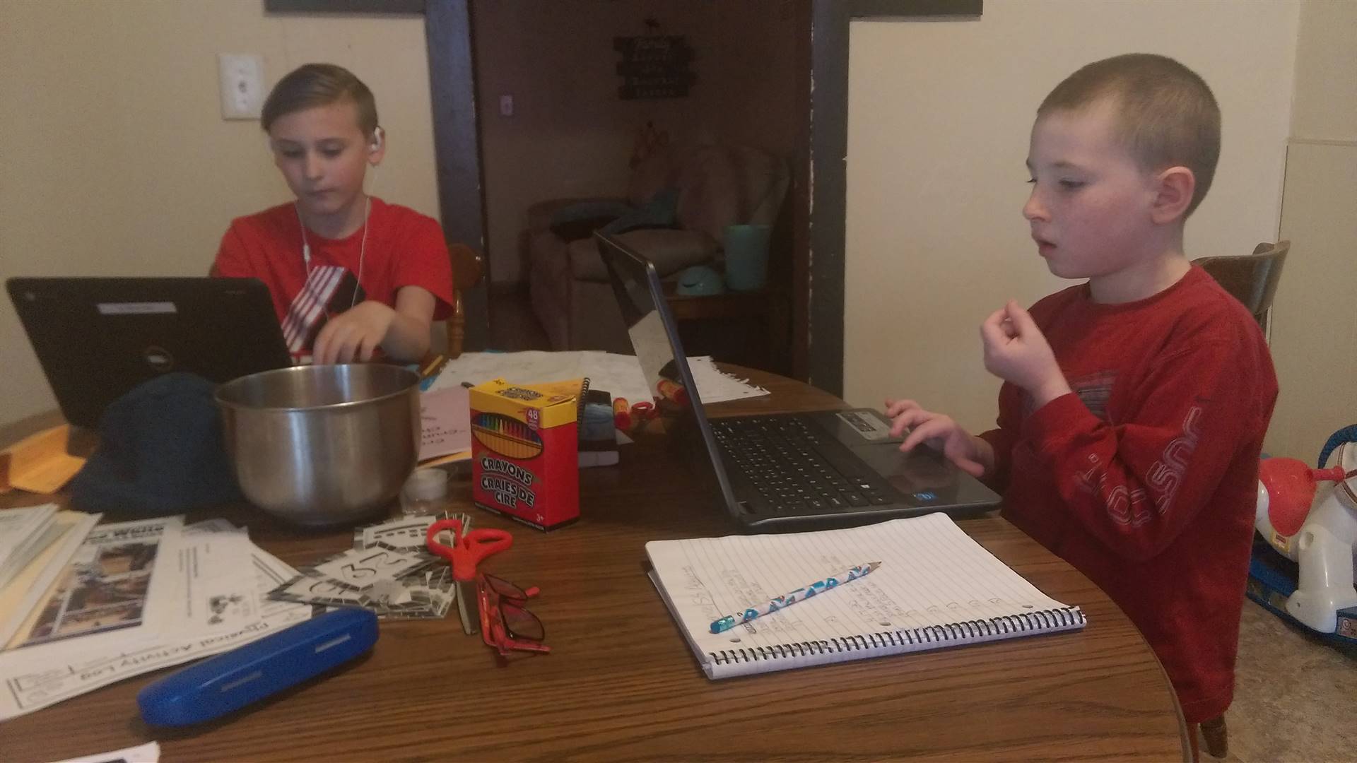 siblings doing schoolwork at table