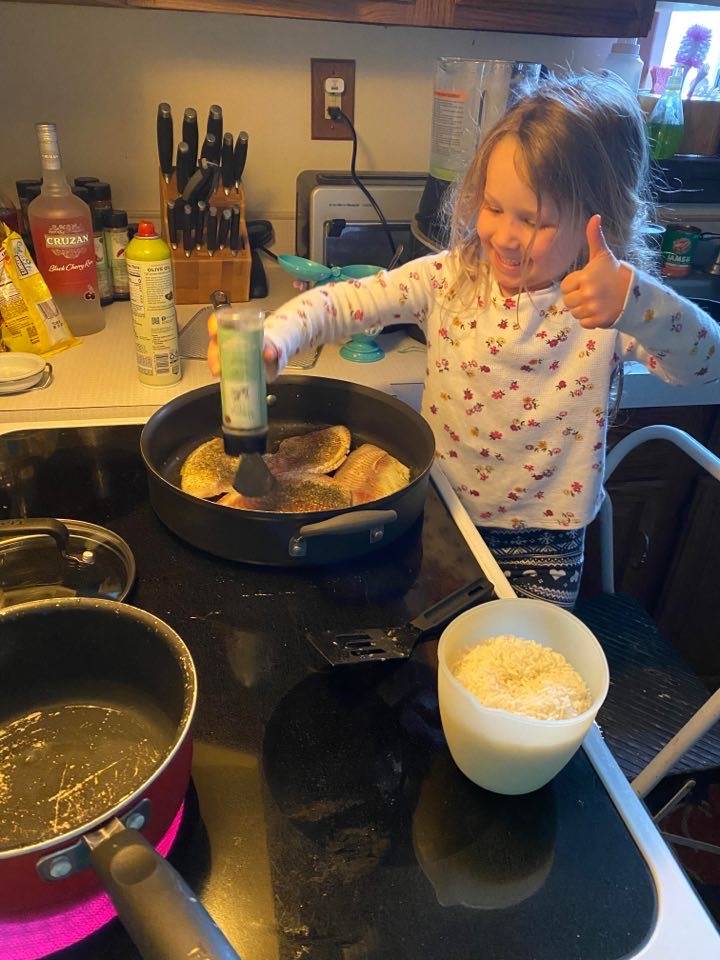 student sprinkling spices into the pan.