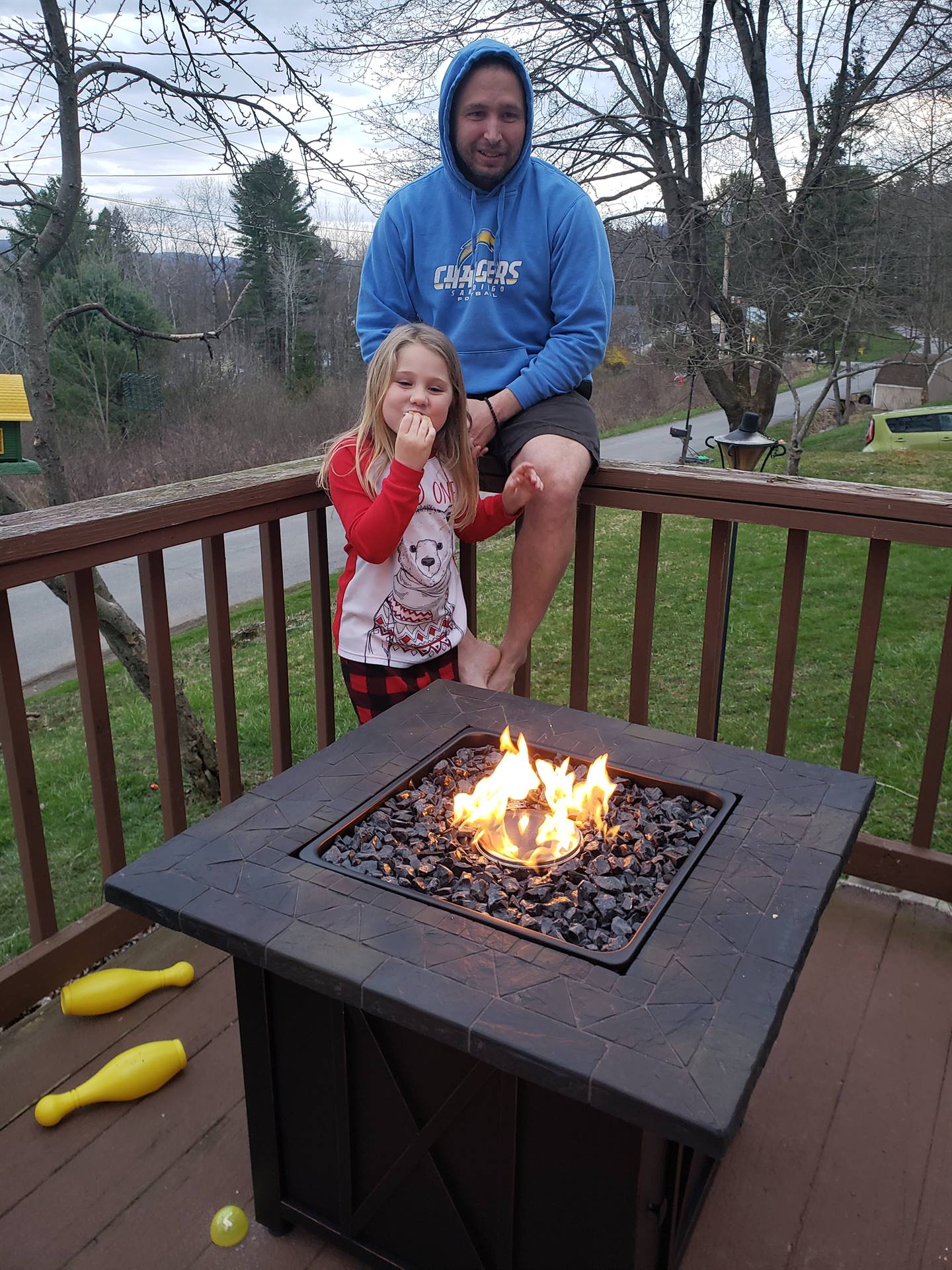 A child and her dad by the fire.