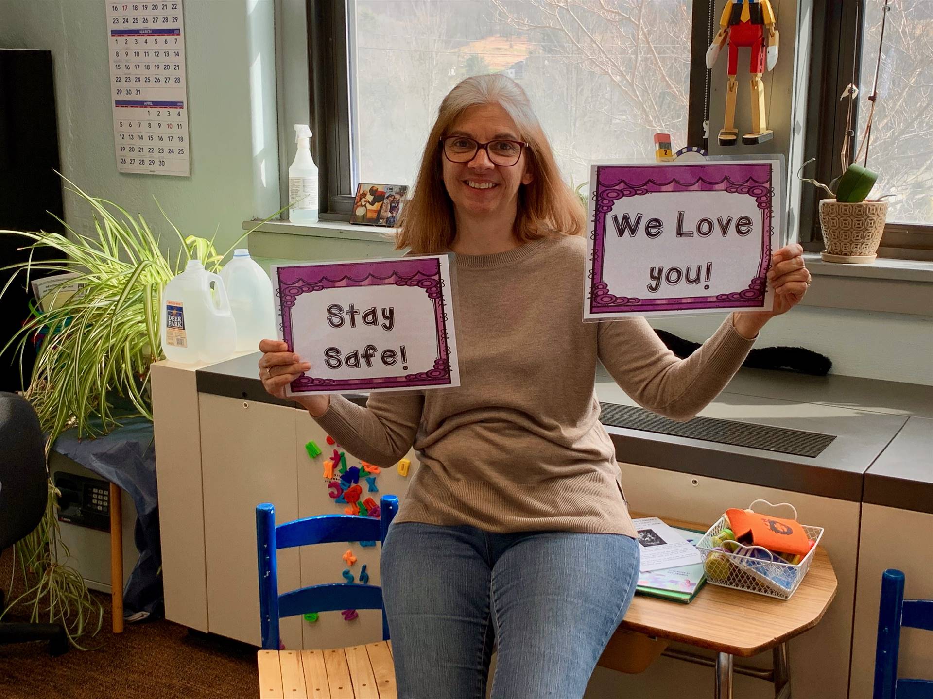 Guilford Principal with signs saying stay safe and We love you!