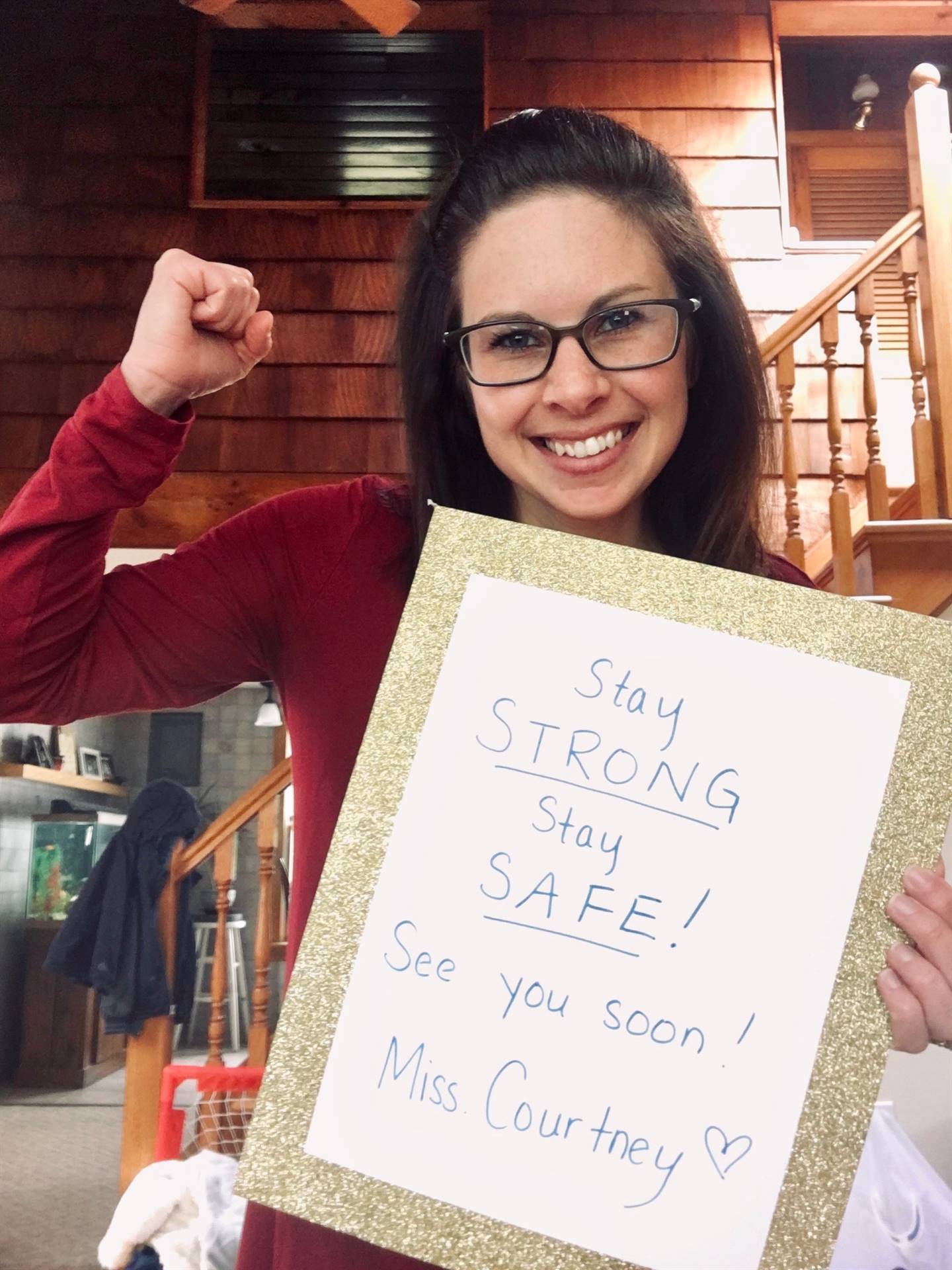 staff member holding up sign "Stay strong stay safe"