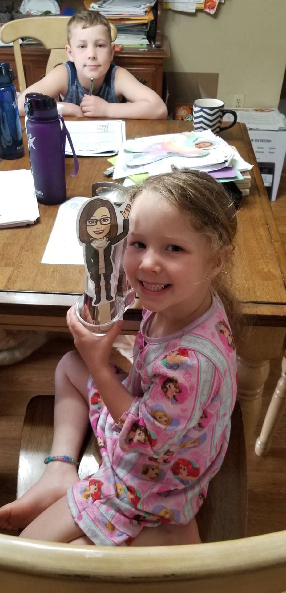 a student shows her paper doll teacher.