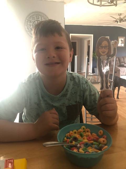 a student eats fruit loops with paper doll teacher.