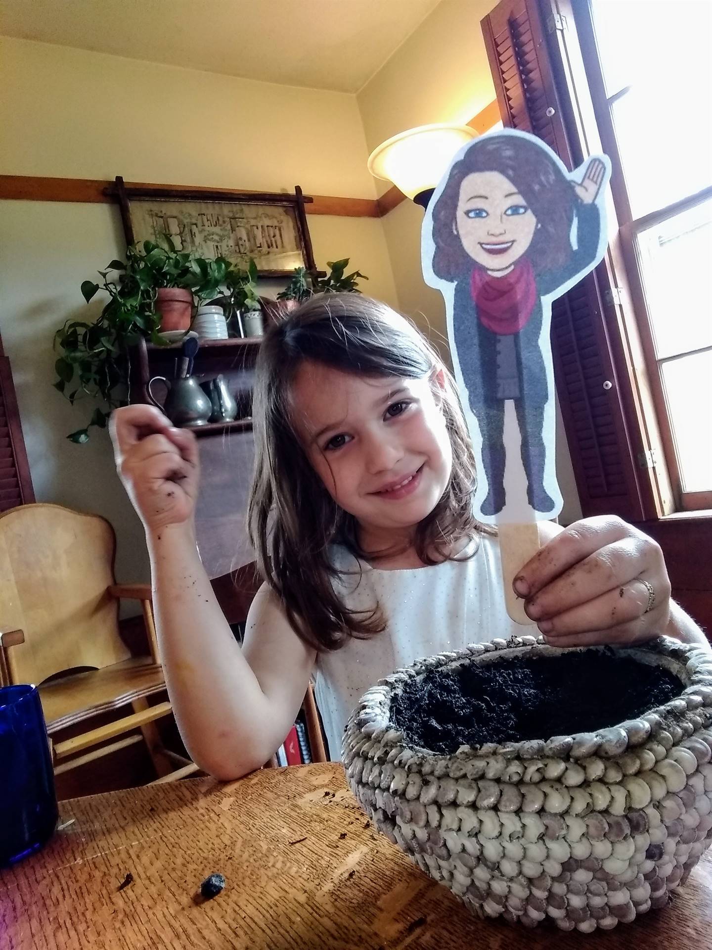 A student plants seed with paper doll teacher.