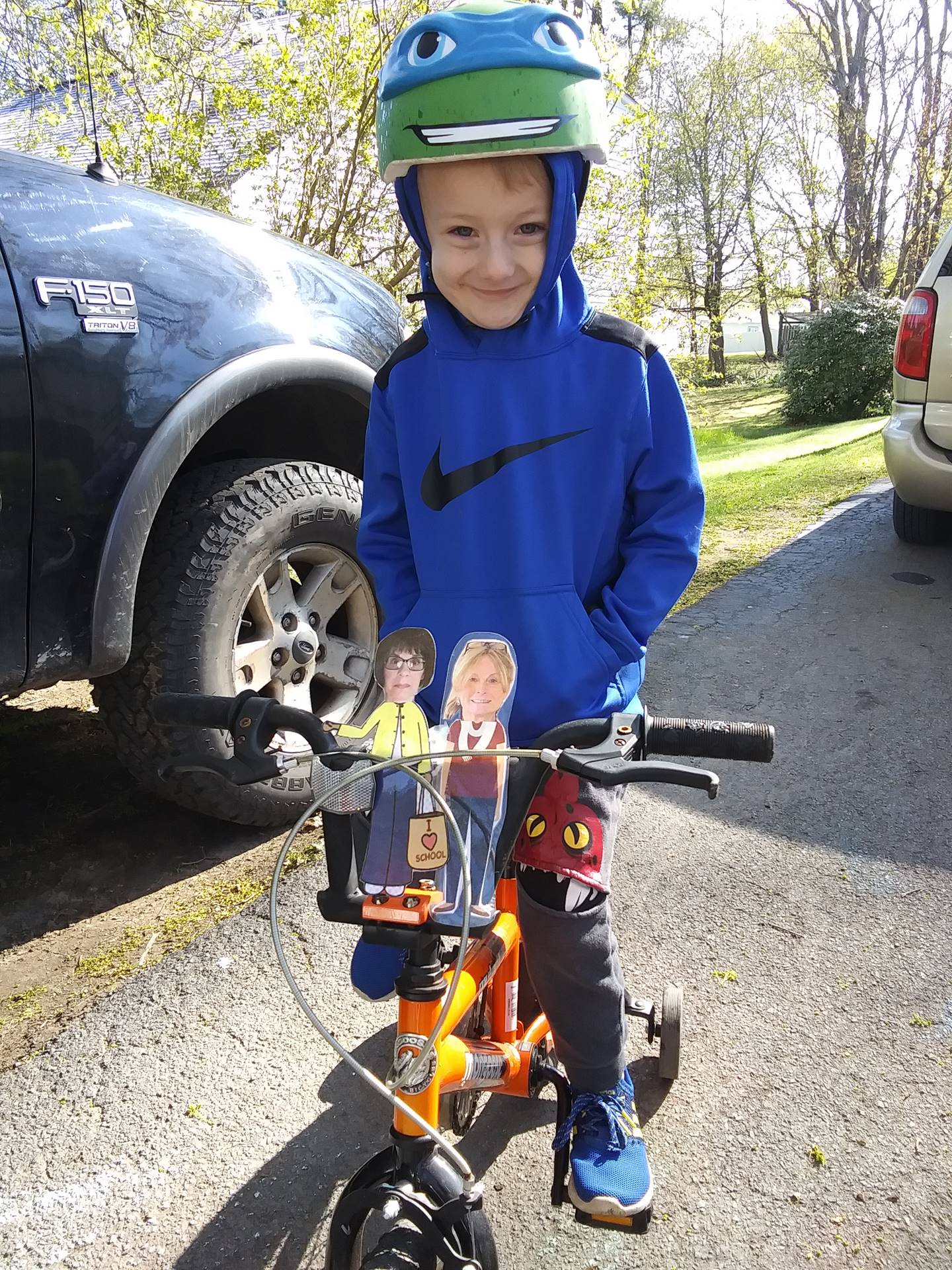 Boy taking his paper doll teachers for a bike ride.