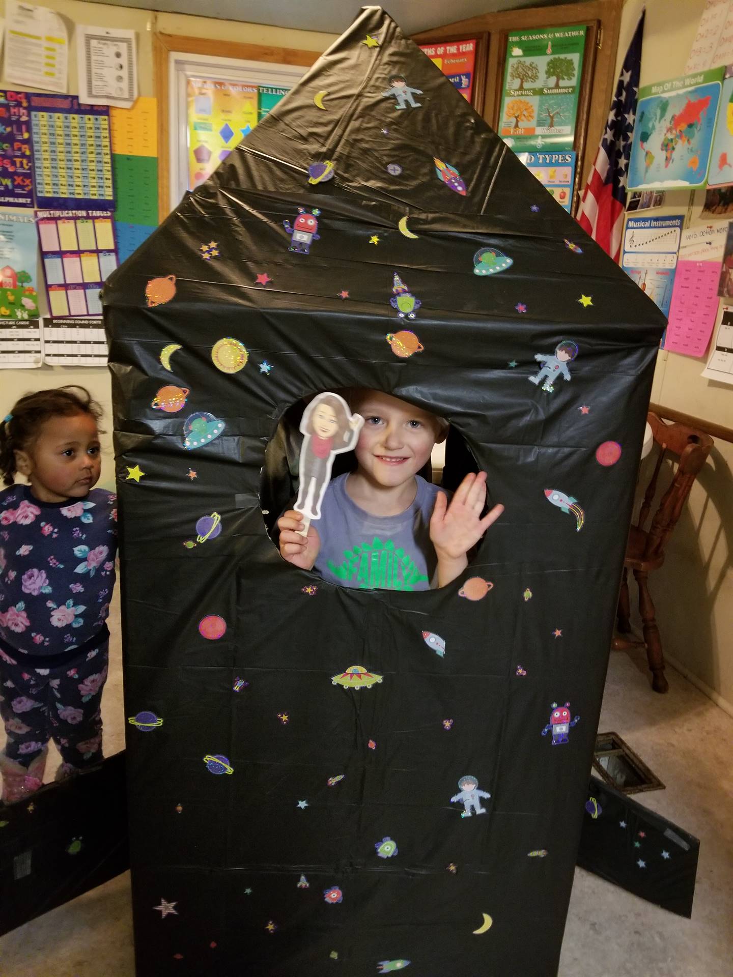 Student in tent with paper doll teacher.