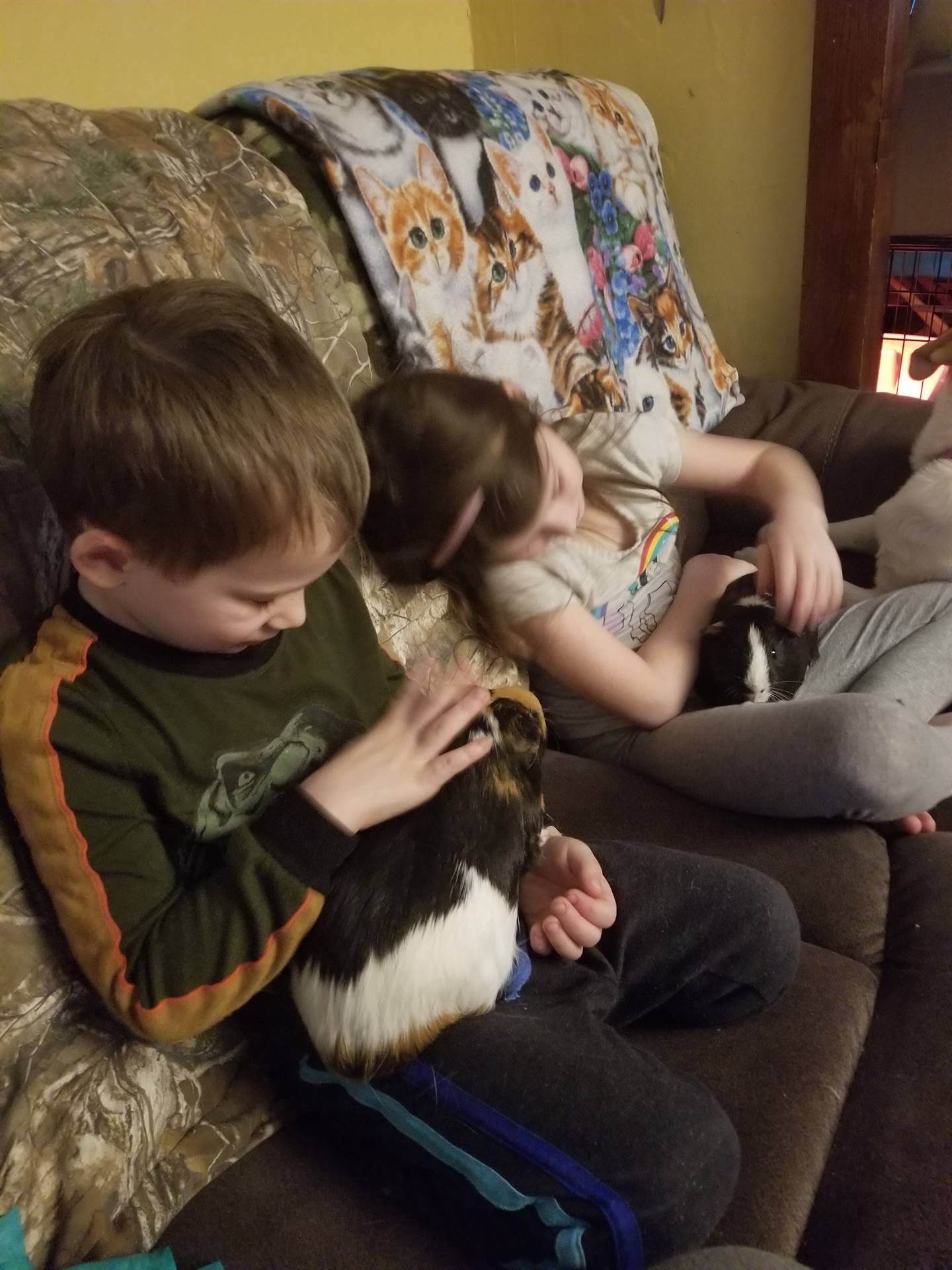 a student and sibling both holding guinea pigs.