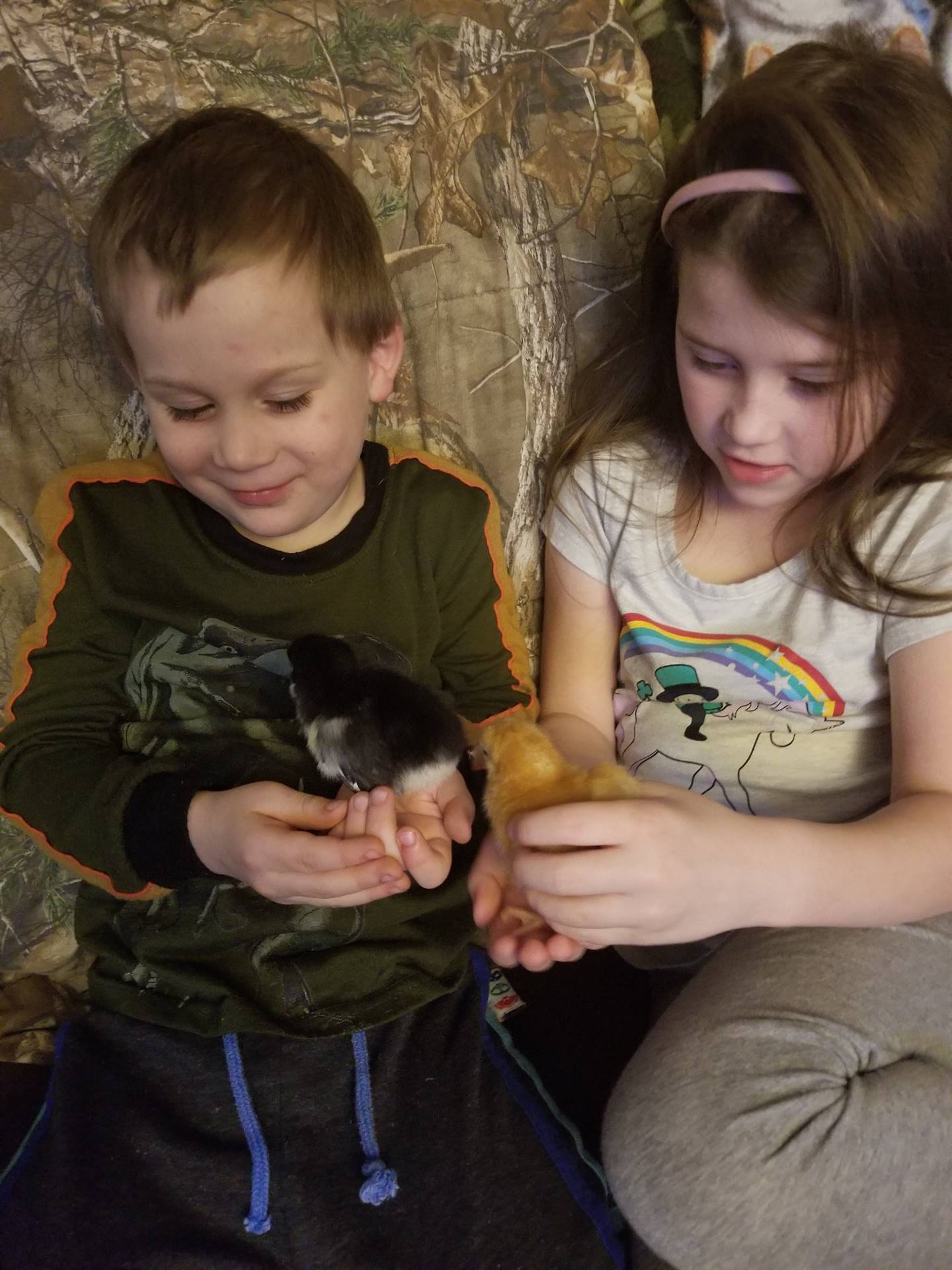 A student and sibling with baby chicks.