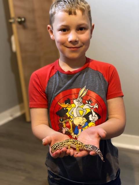 A student holds a critter in his hands.