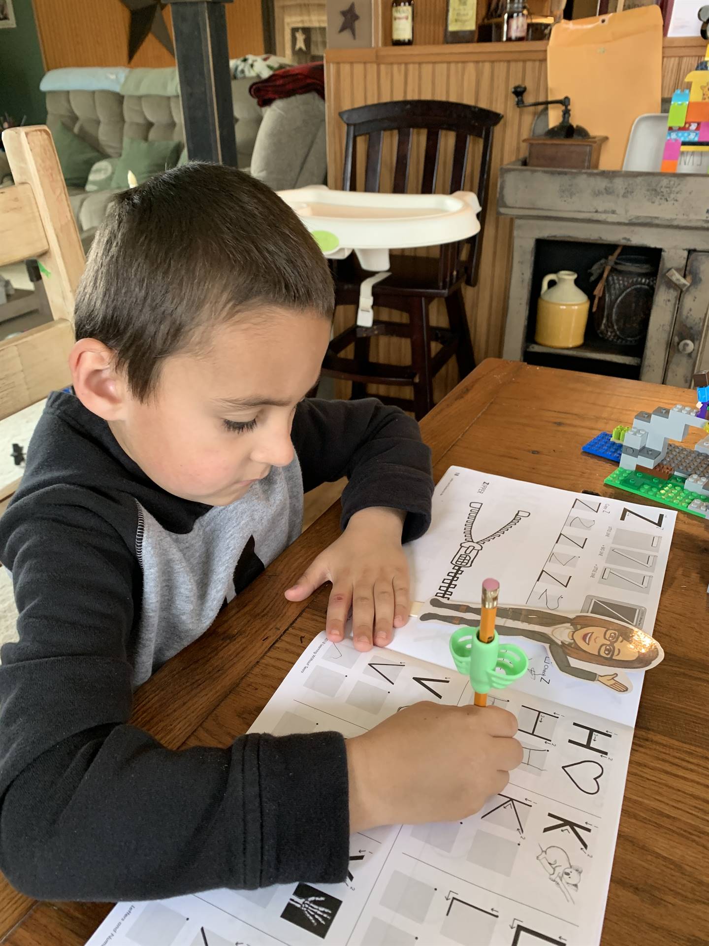 student with paper doll teacher doing letters.