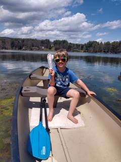 a student on a boat on a lake with paper doll teacher!