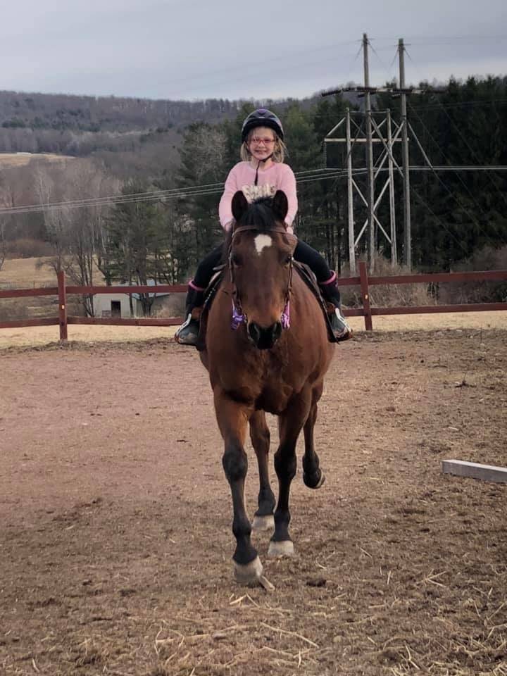 a student riding on a horse.