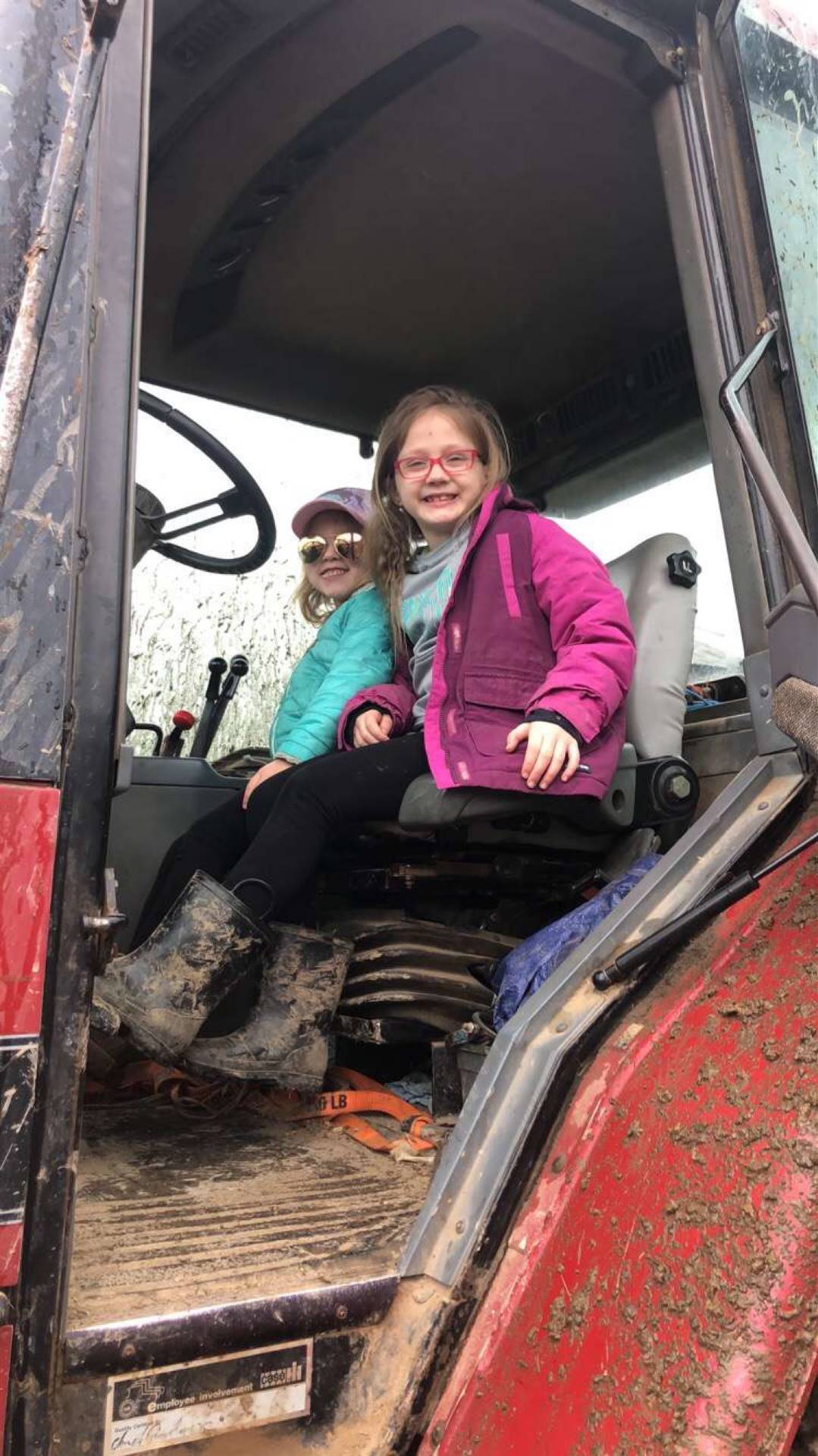 2 kids inside a large tractor.