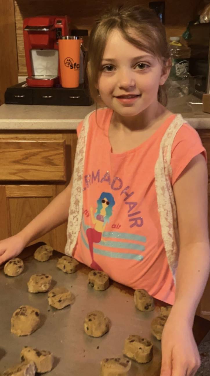 student with unbaked cookies on a sheet!