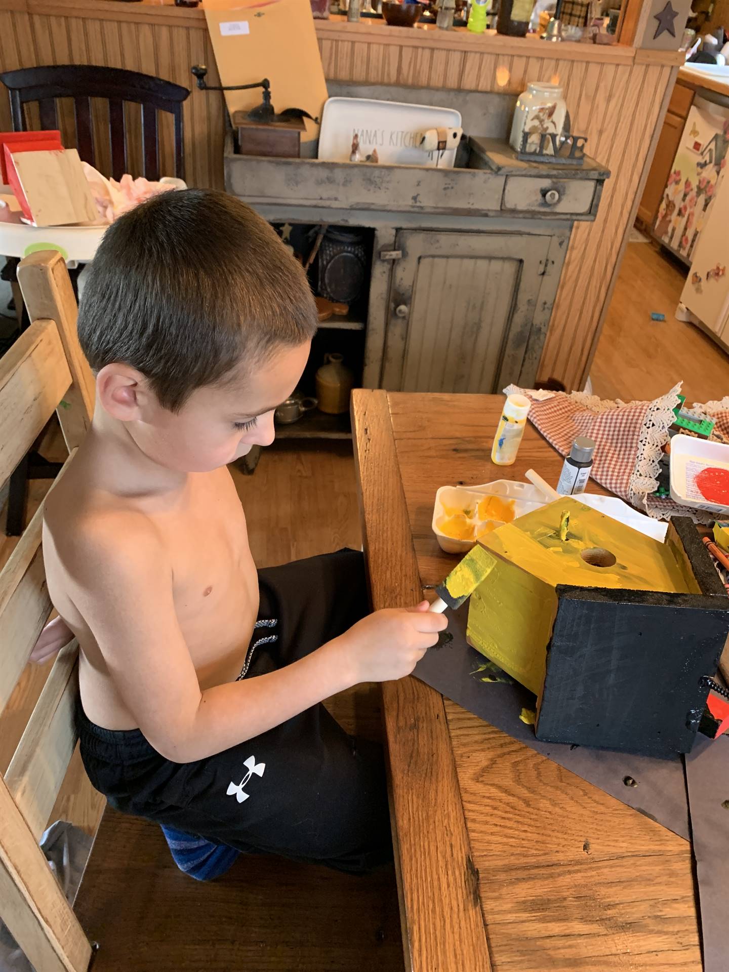 boy painting bird house.