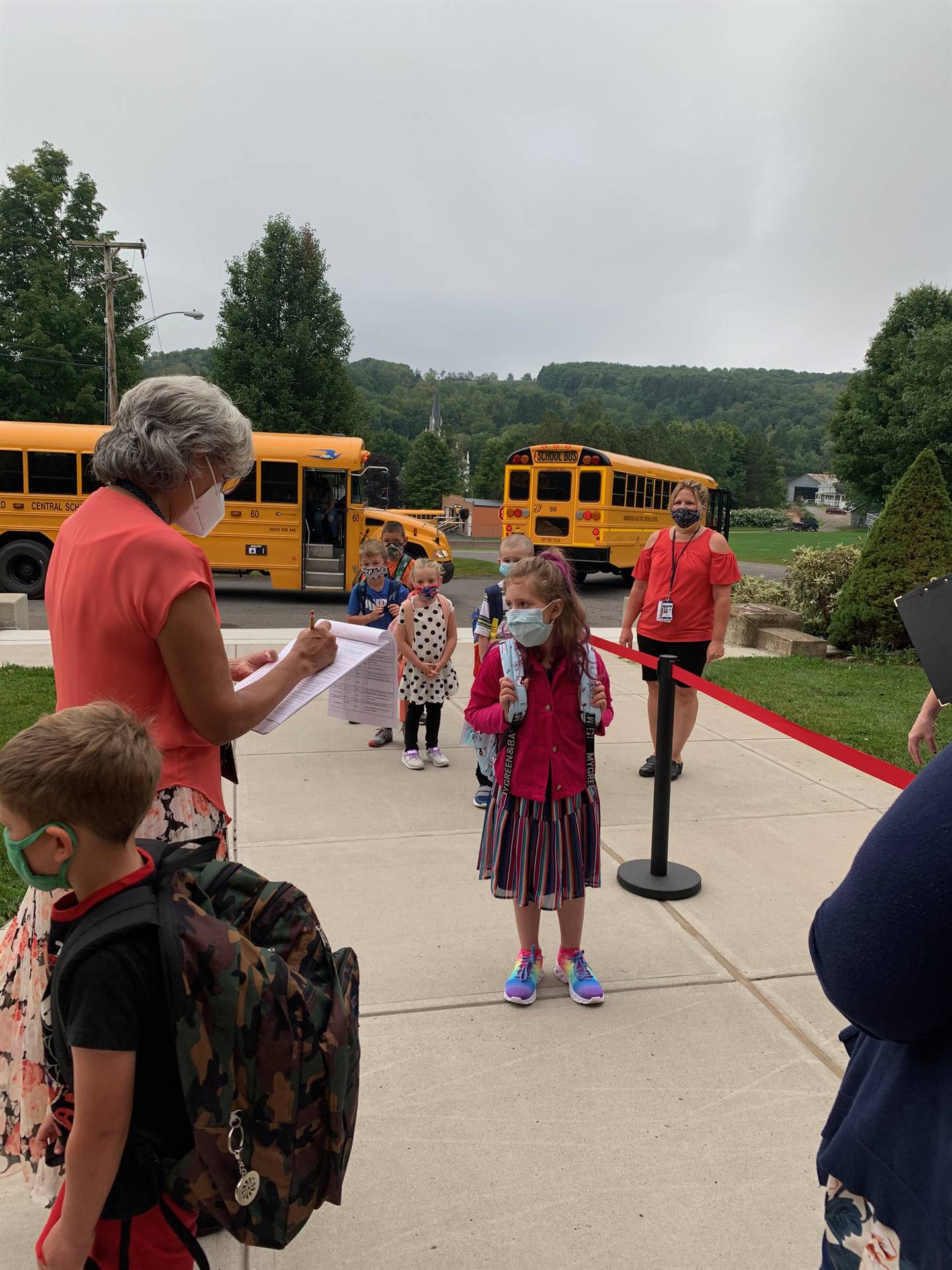 students lined up off the bus waiting for temp checks!