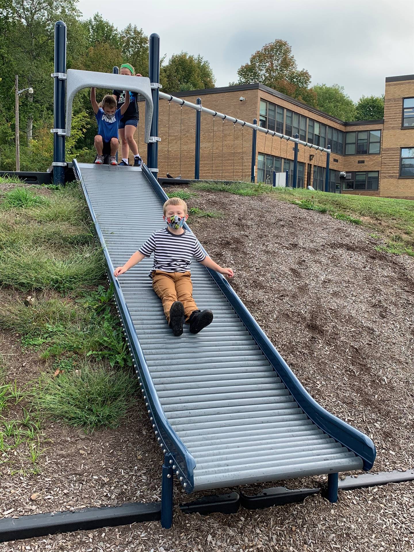 student sliding down slide.