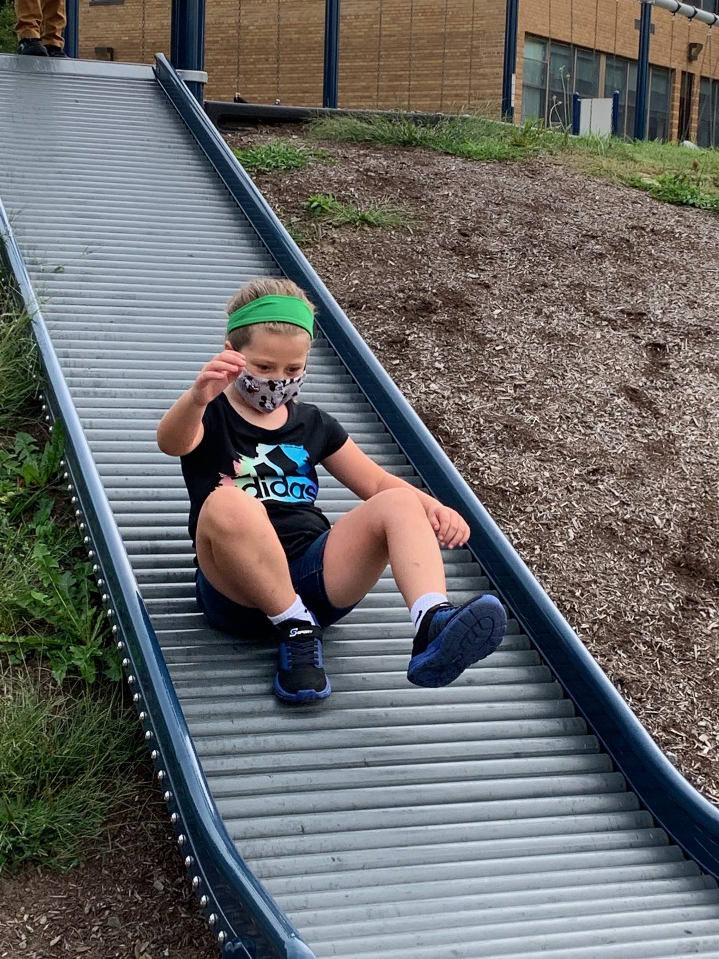 student sliding down slide.