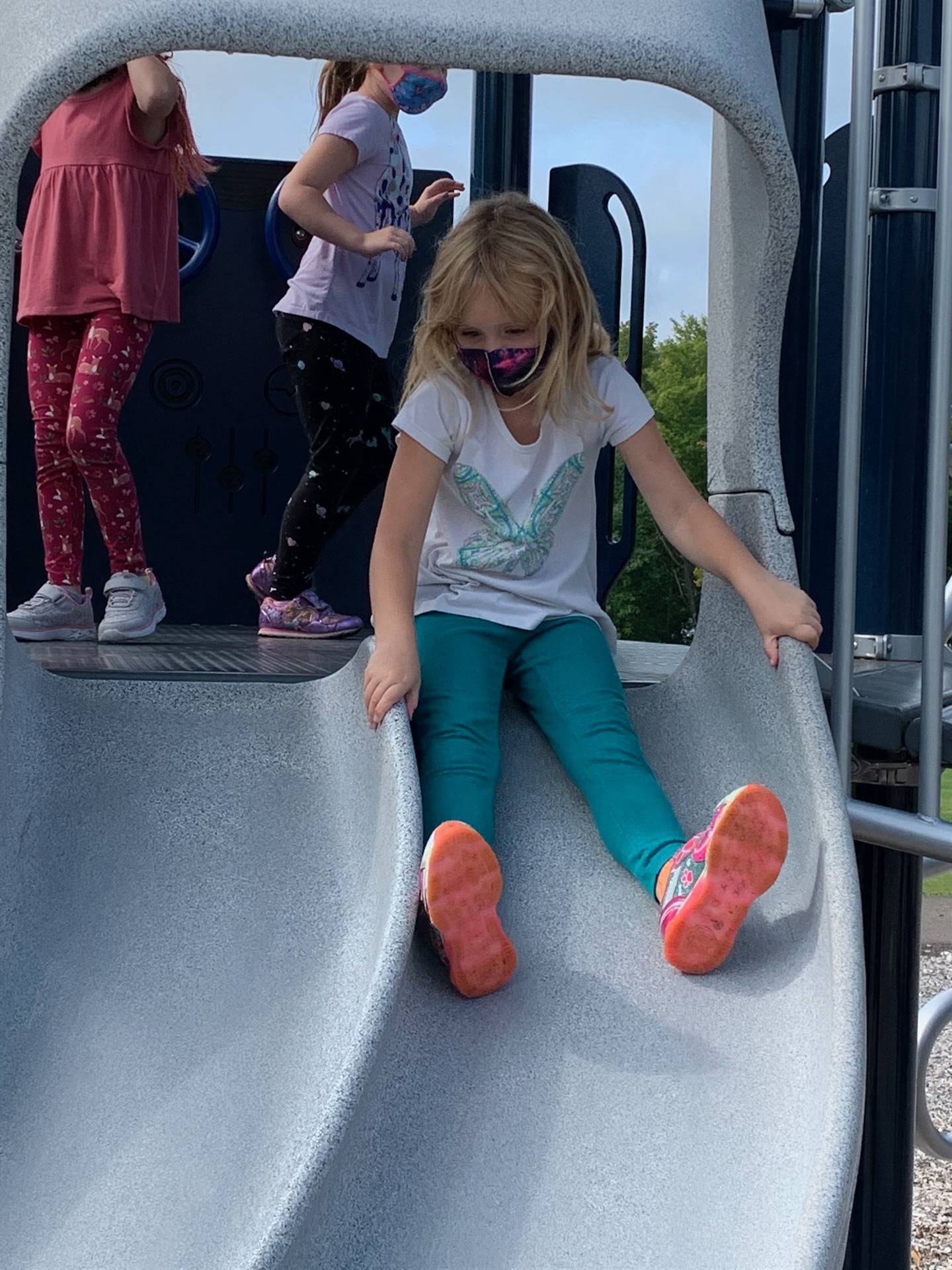 student sliding down slide.