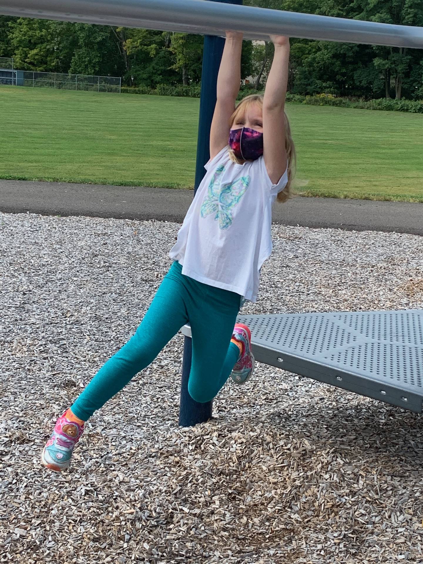 a student hangs on monkey bars.